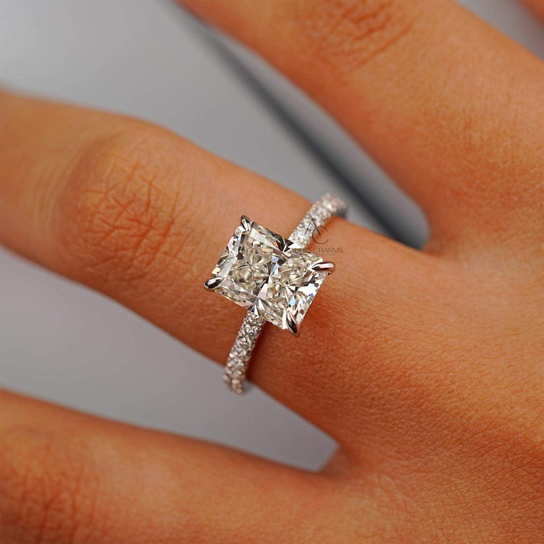 Radiant-cut diamond ring on a hand, highlighting its sparkle and detailed craftsmanship.