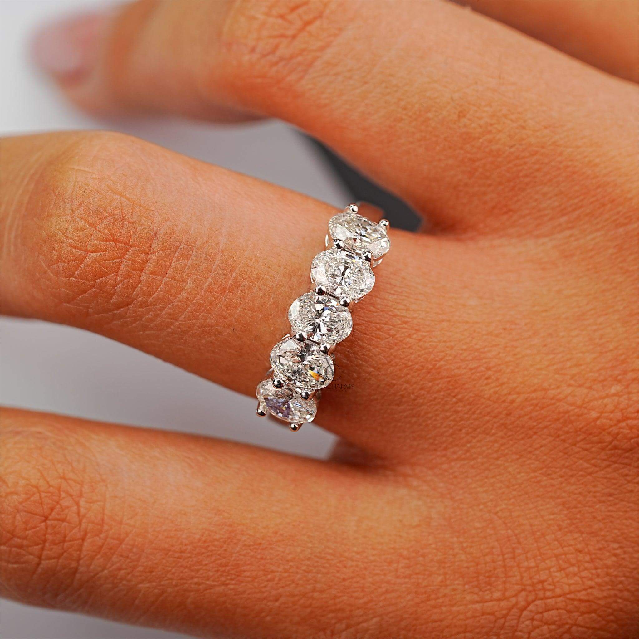 Hand wearing a dazzling five-stone lab-grown diamond band, perfect for timeless elegance.