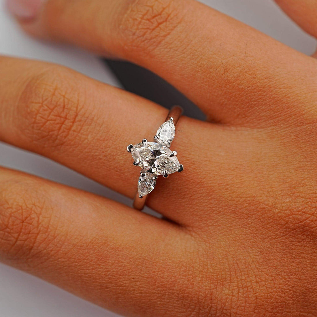 Marquise diamond ring with pear accents worn on hand, showcasing brilliant sparkle and fit.