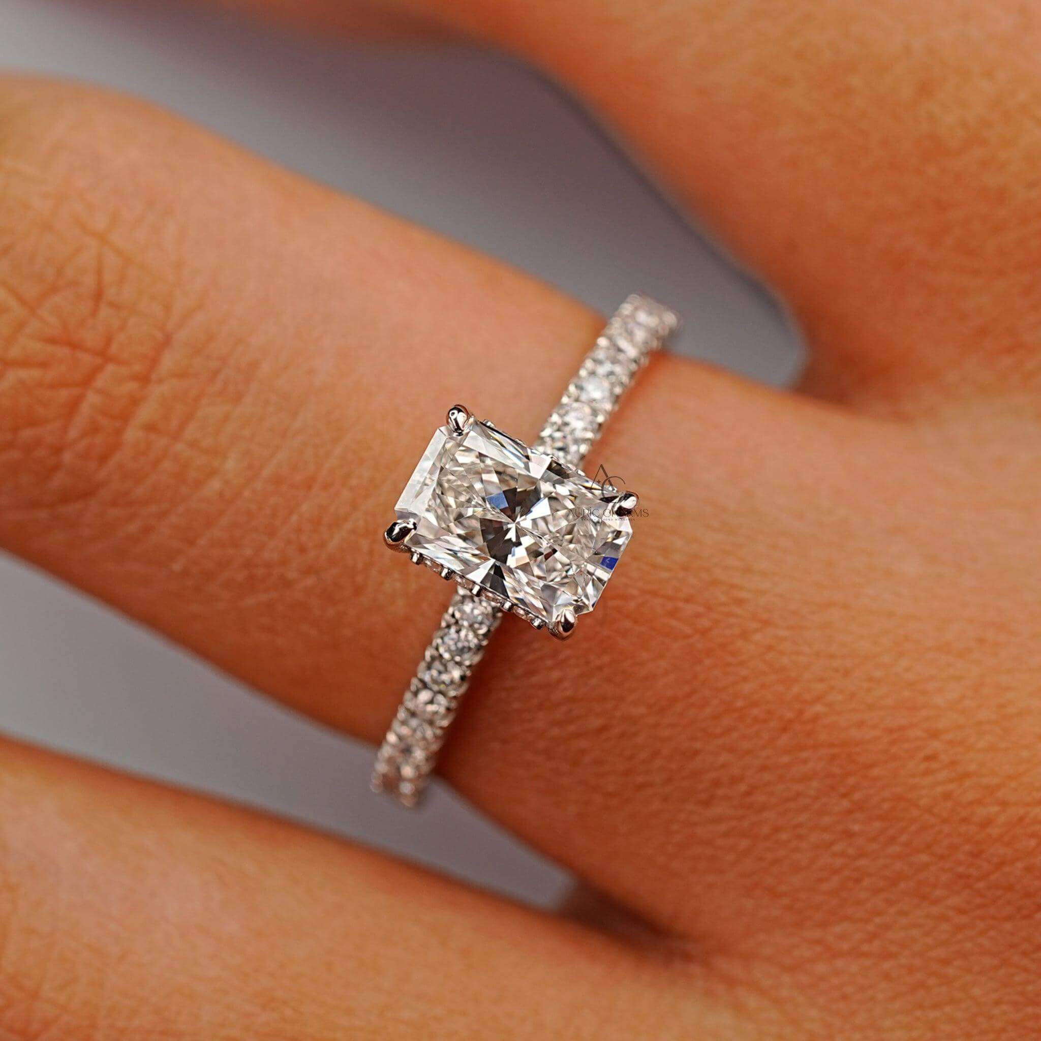 Radiant diamond ring displayed on finger, emphasizing brilliance and pavé craftsmanship.