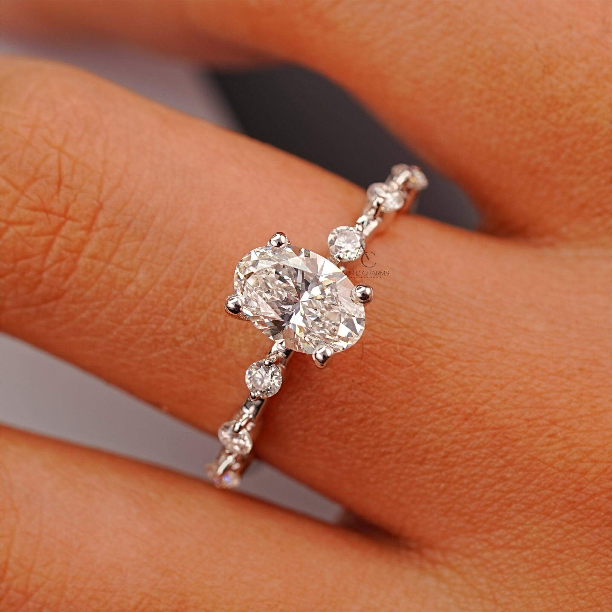 Close-up of an oval diamond engagement ring with brilliant sparkle on a reflective surface.