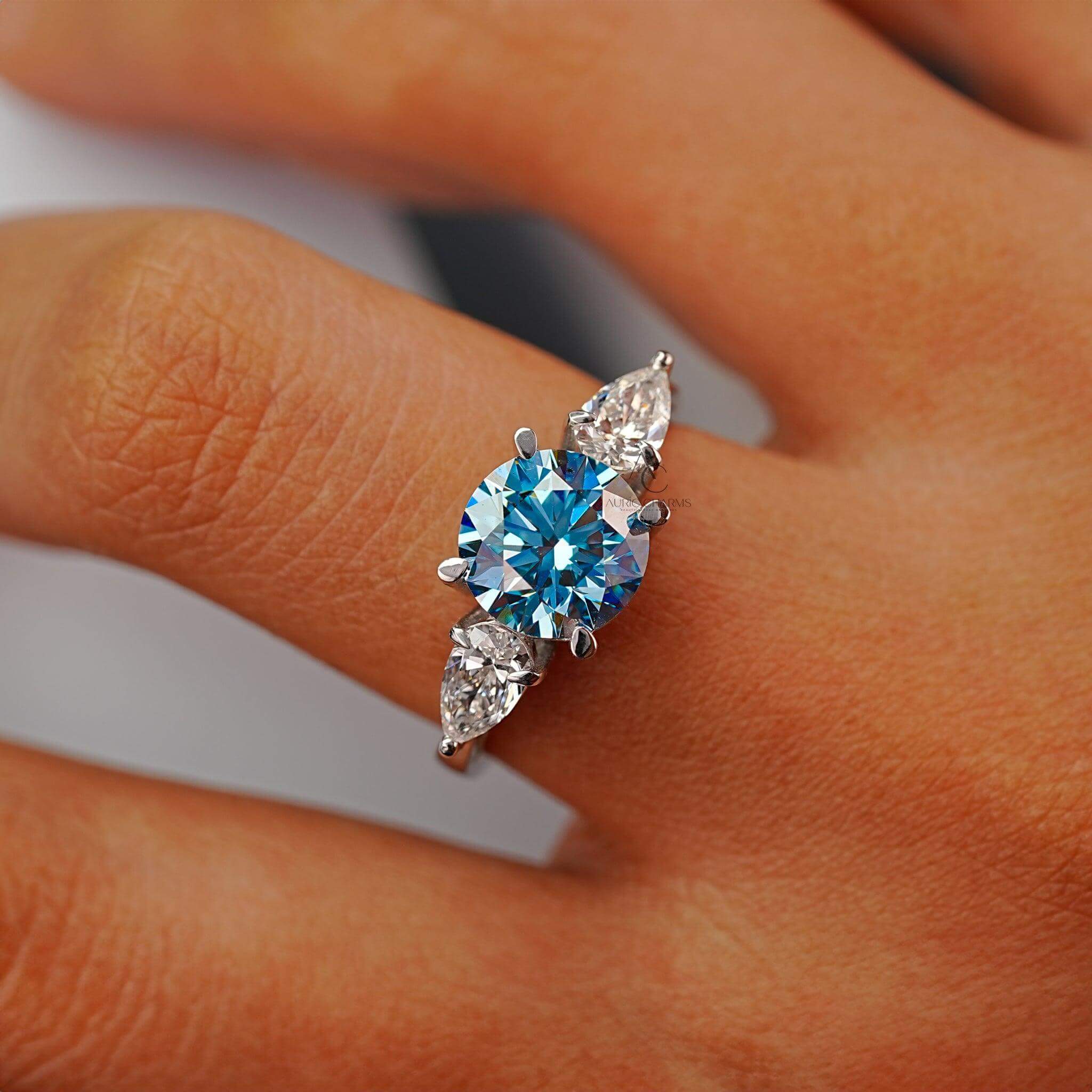 Close-up of a round blue diamond ring with pear-shaped diamonds, exuding luxury and brilliance.