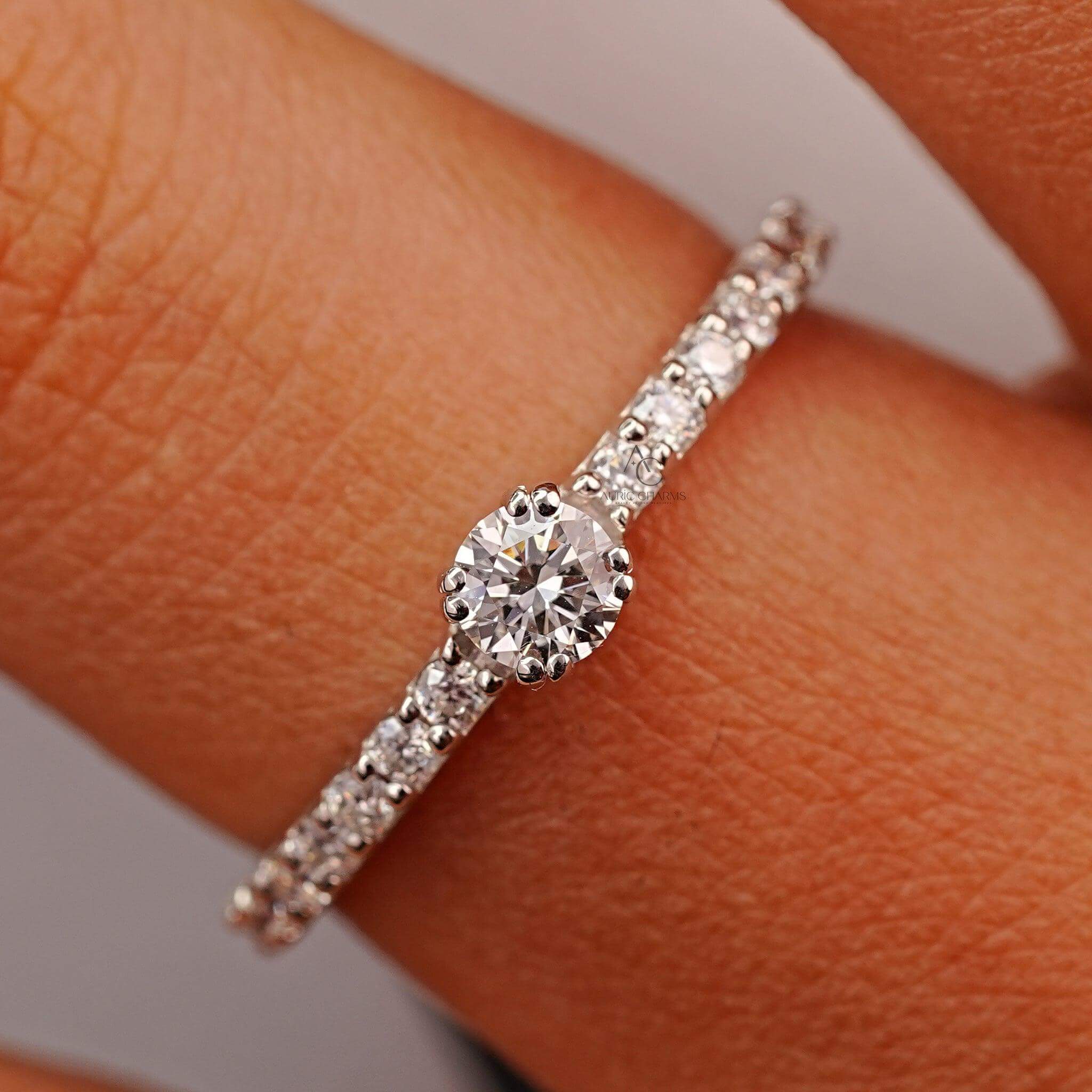 Beautiful round-cut diamond solitaire ring with a pave band worn on a hand, illustrating its timeless elegance for engagements.