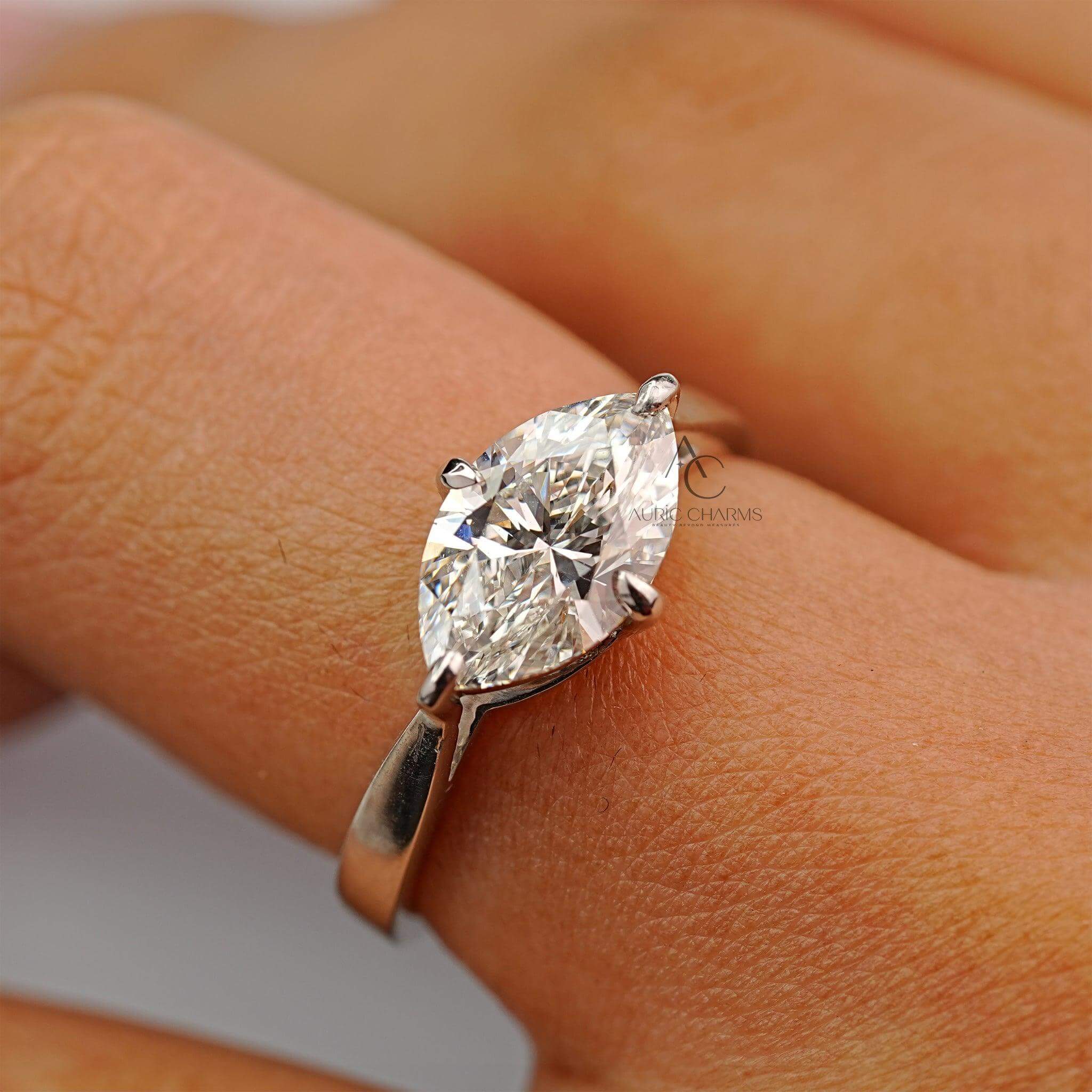 Close-up of marquise diamond engagement ring on hand, highlighting its brilliance and sleek setting.