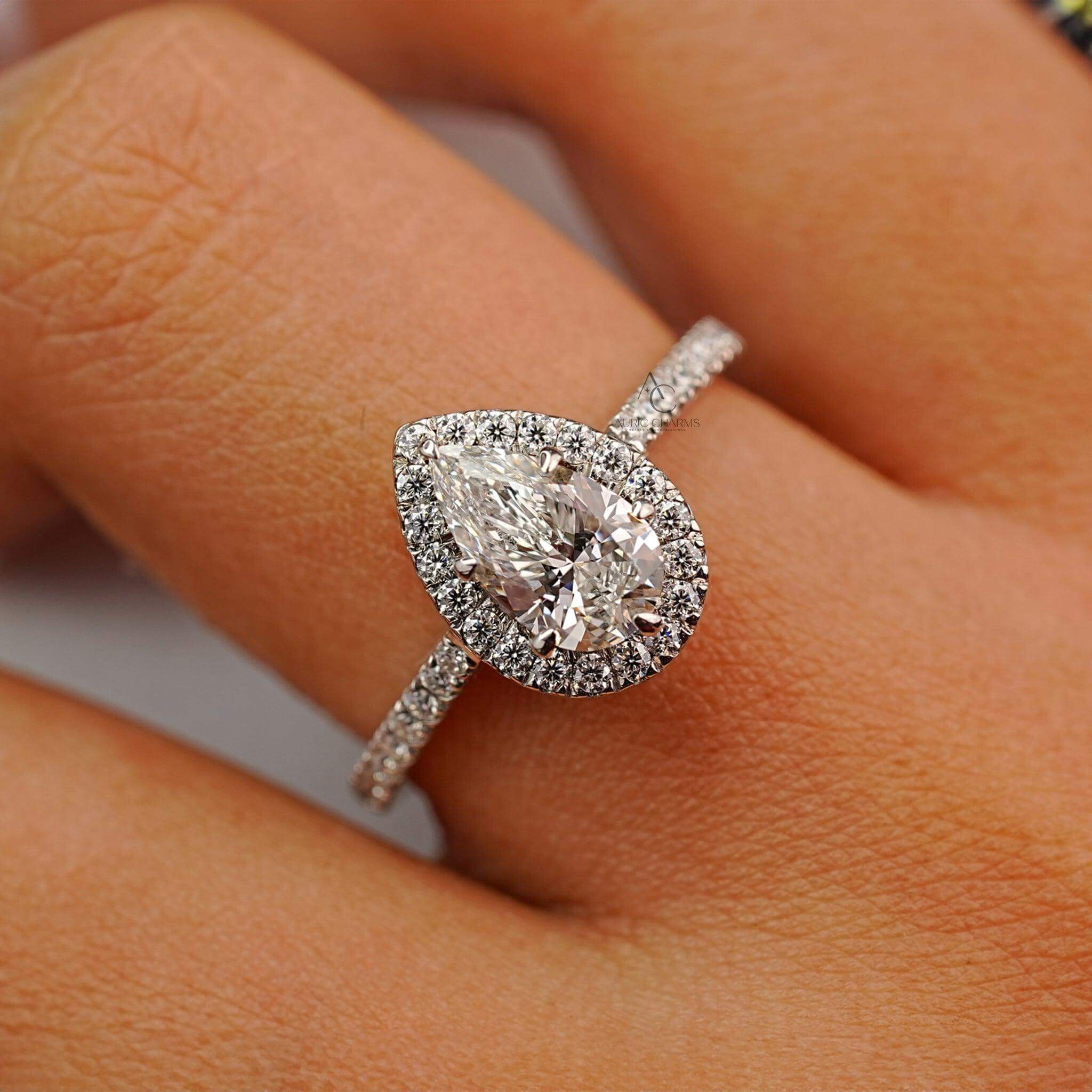 Close-up of a pear-cut diamond ring on hand, highlighting sparkle and craftsmanship.