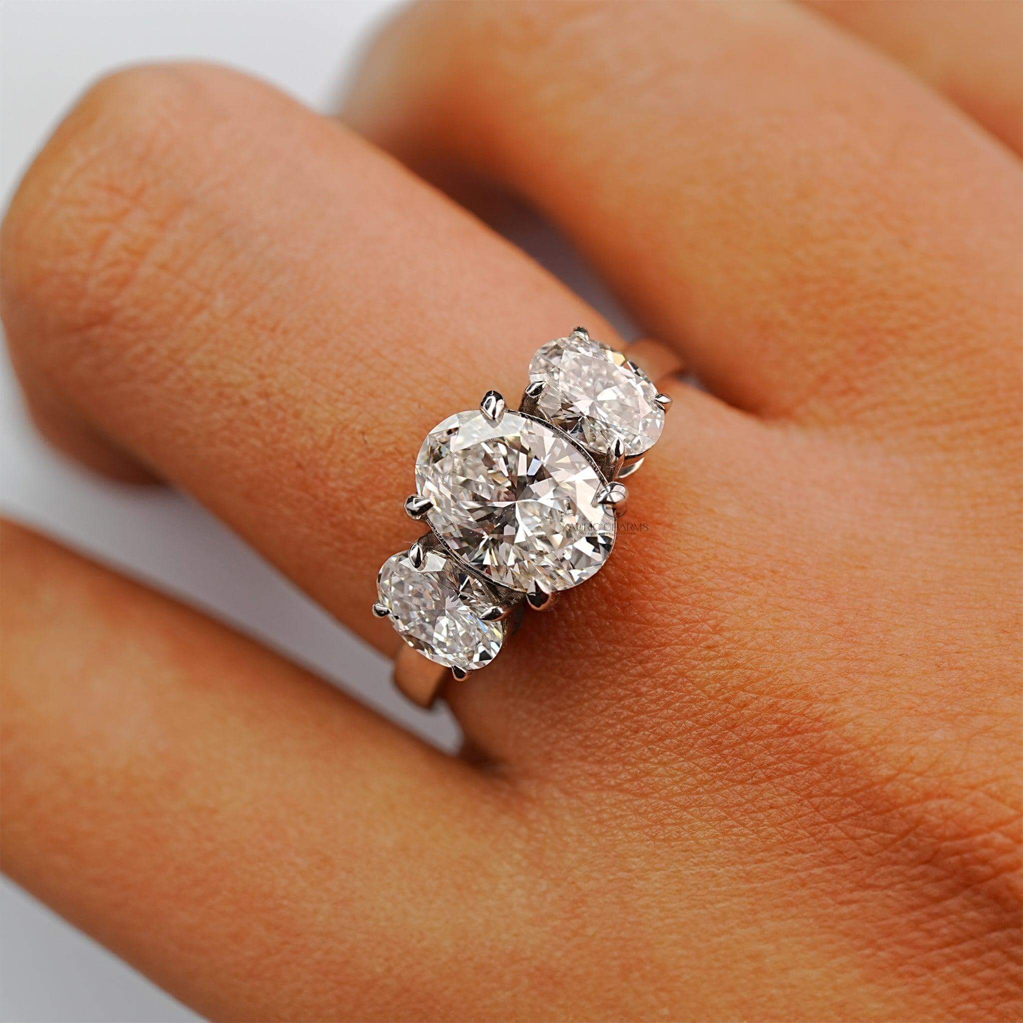 Three-stone oval diamond engagement ring with lab-grown diamonds, displayed on a hand elegantly