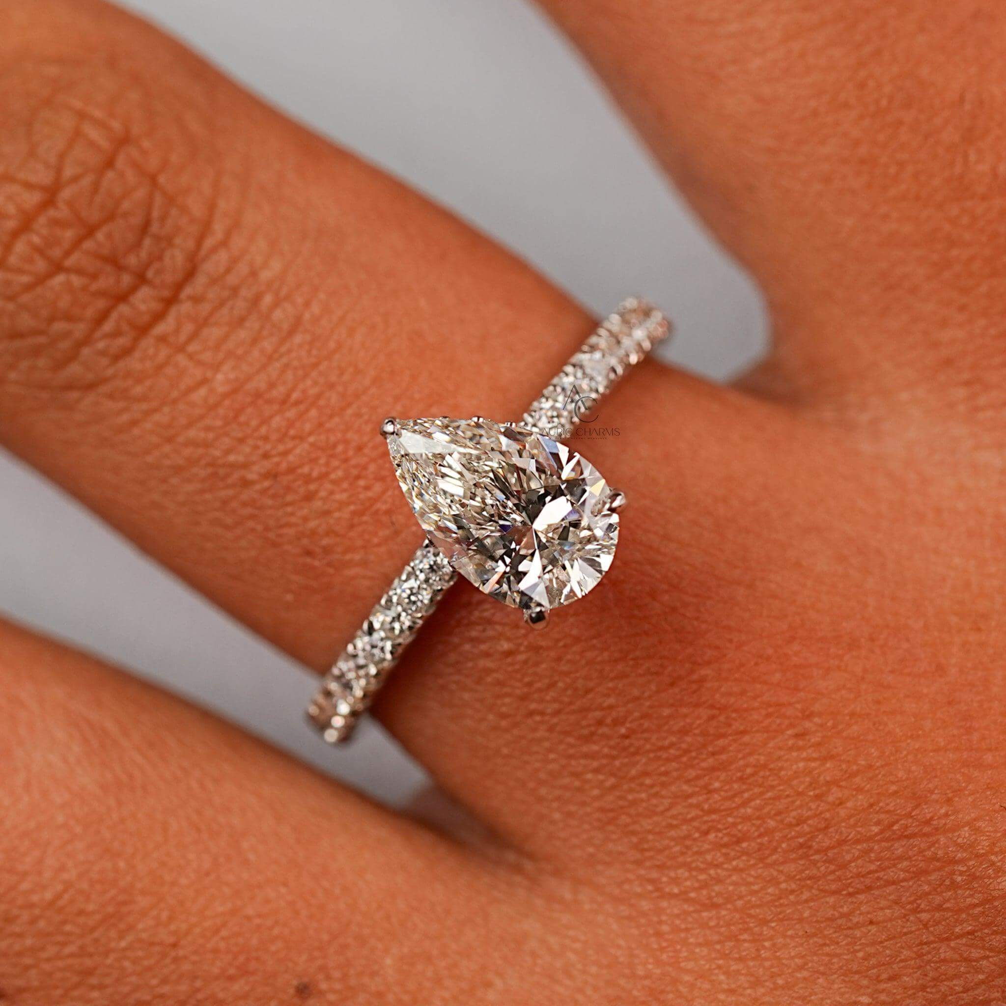 Pear-cut diamond ring worn on a hand, highlighting its brilliance and elegance.