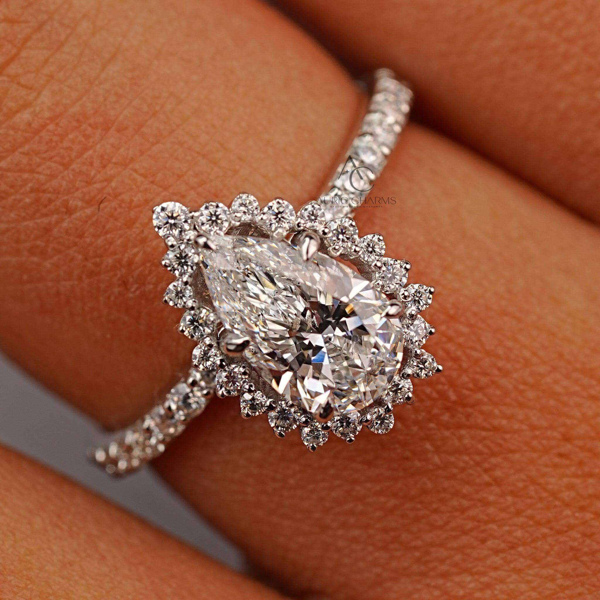 Back view of pear-shaped halo diamond ring with pave accents reflecting under soft lighting