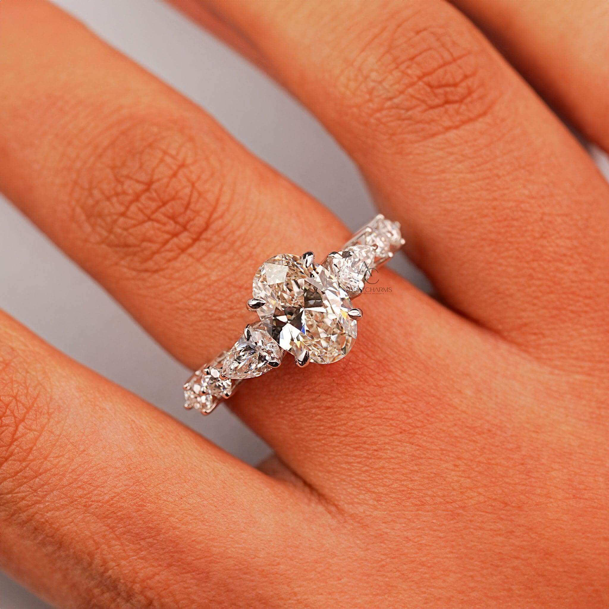 Stunning oval diamond engagement ring on finger, paired with exquisite side stones for a timeless look.
