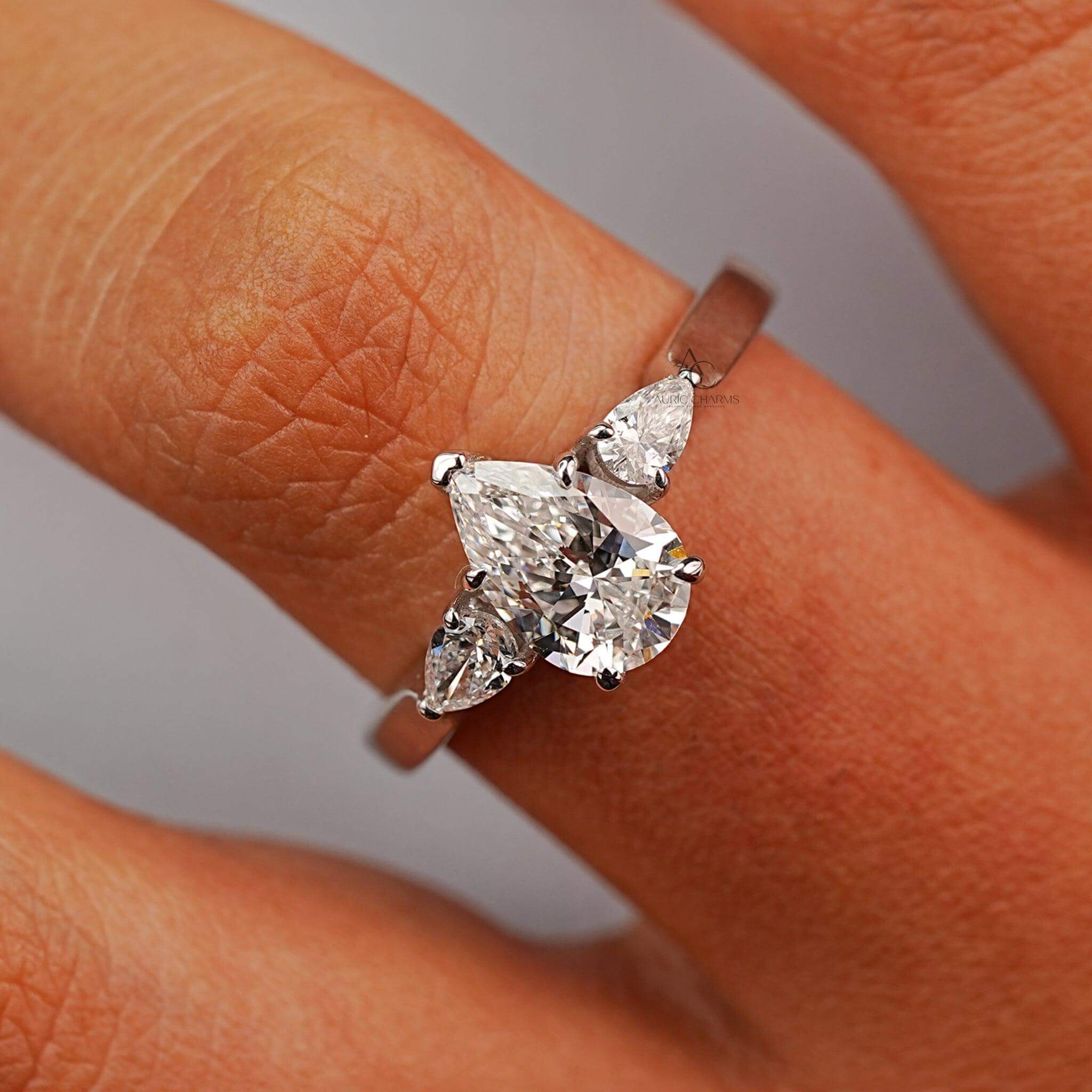 Hand model showcasing a pear-cut diamond ring, a symbol of luxury and timeless elegance.