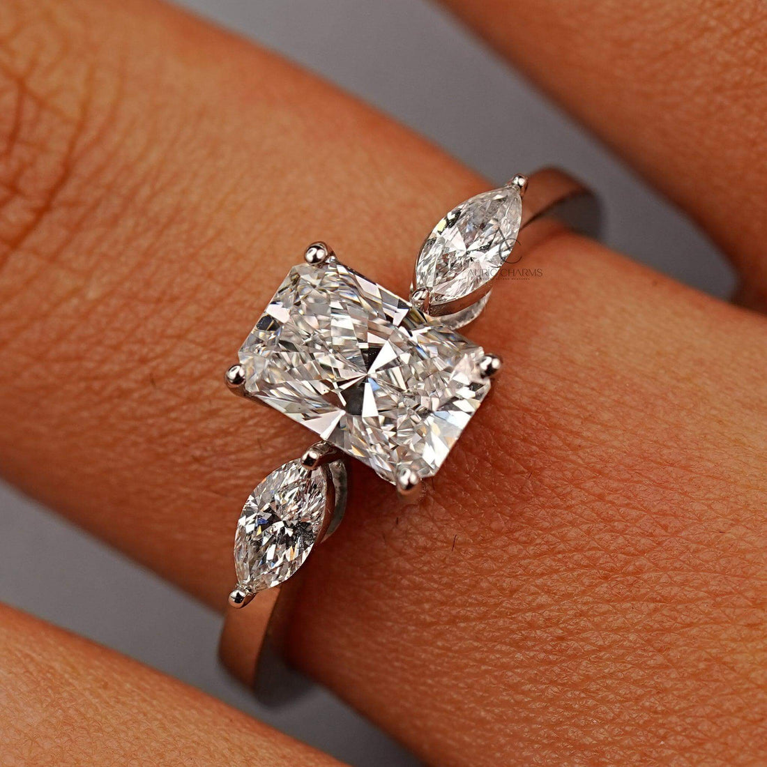 Radiant cut diamond ring with lab-grown stones and marquise accents, reflecting sustainable craftsmanship in a luxurious setting.