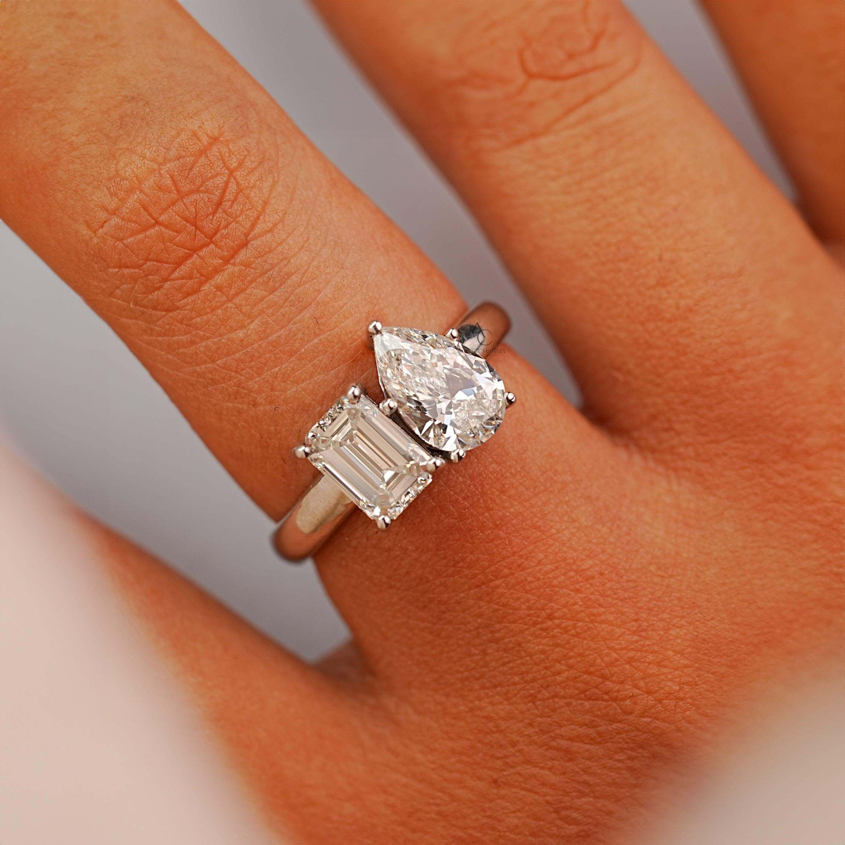 Close-up of Toi et Moi diamond ring with emerald and pear-cut lab-grown diamonds.