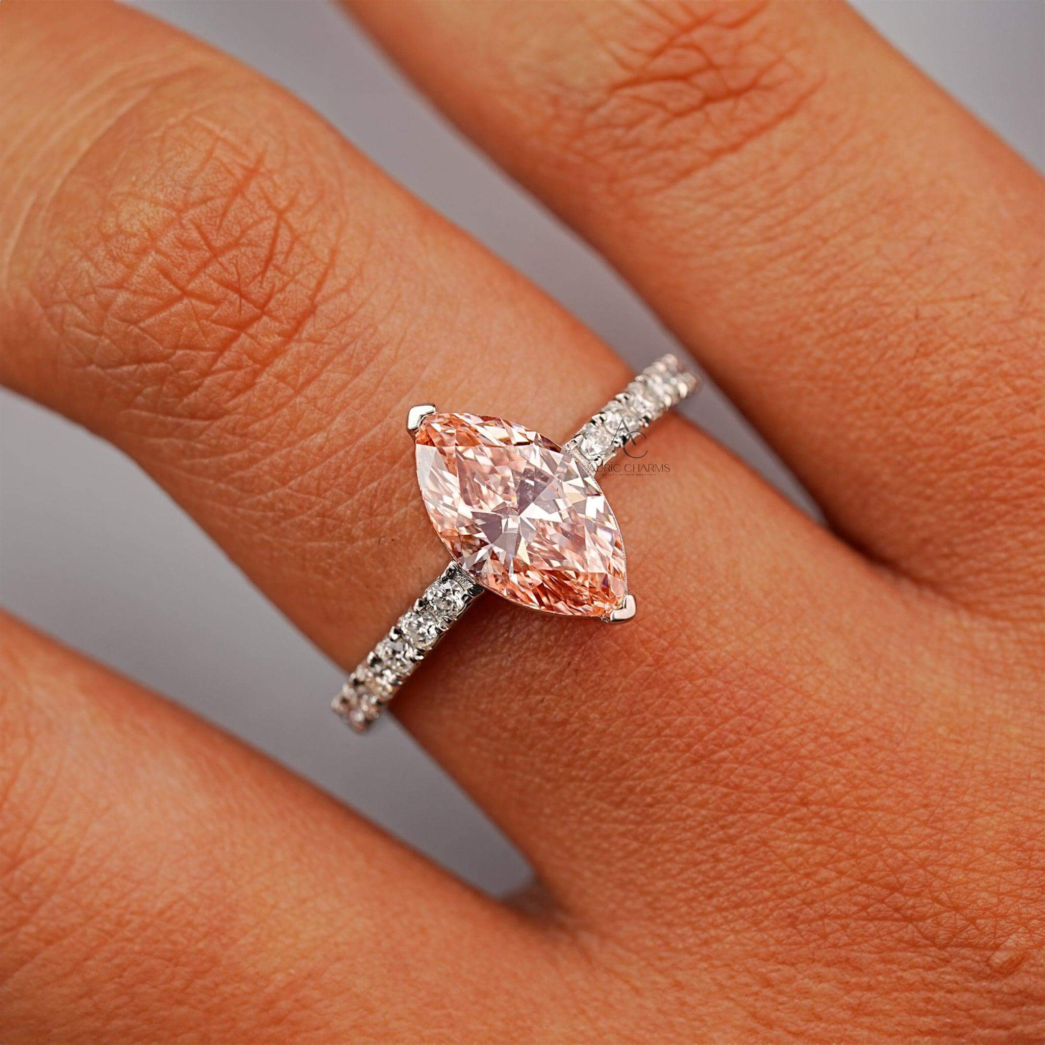 Marquise-cut pink gemstone ring with a diamond-encrusted band in a silver setting.