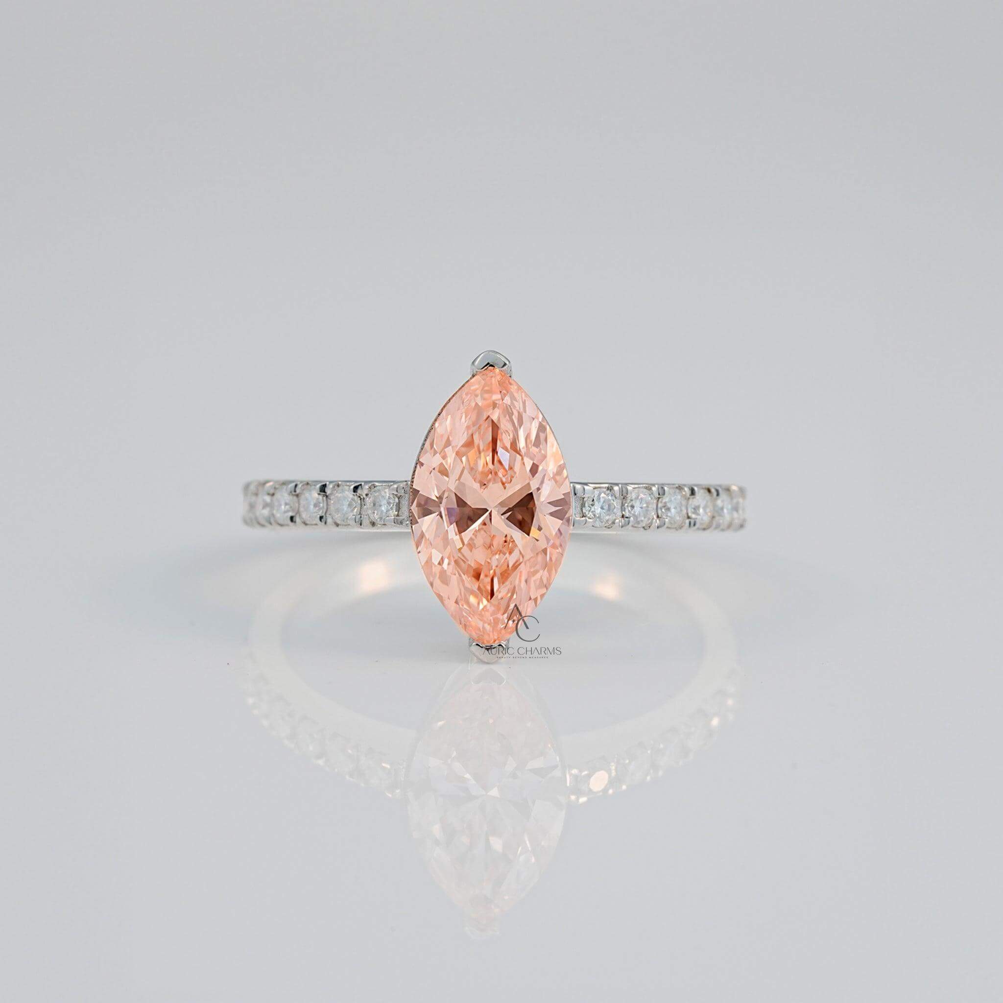 Close-up of a marquise pink gem with a diamond-studded silver band reflecting light.