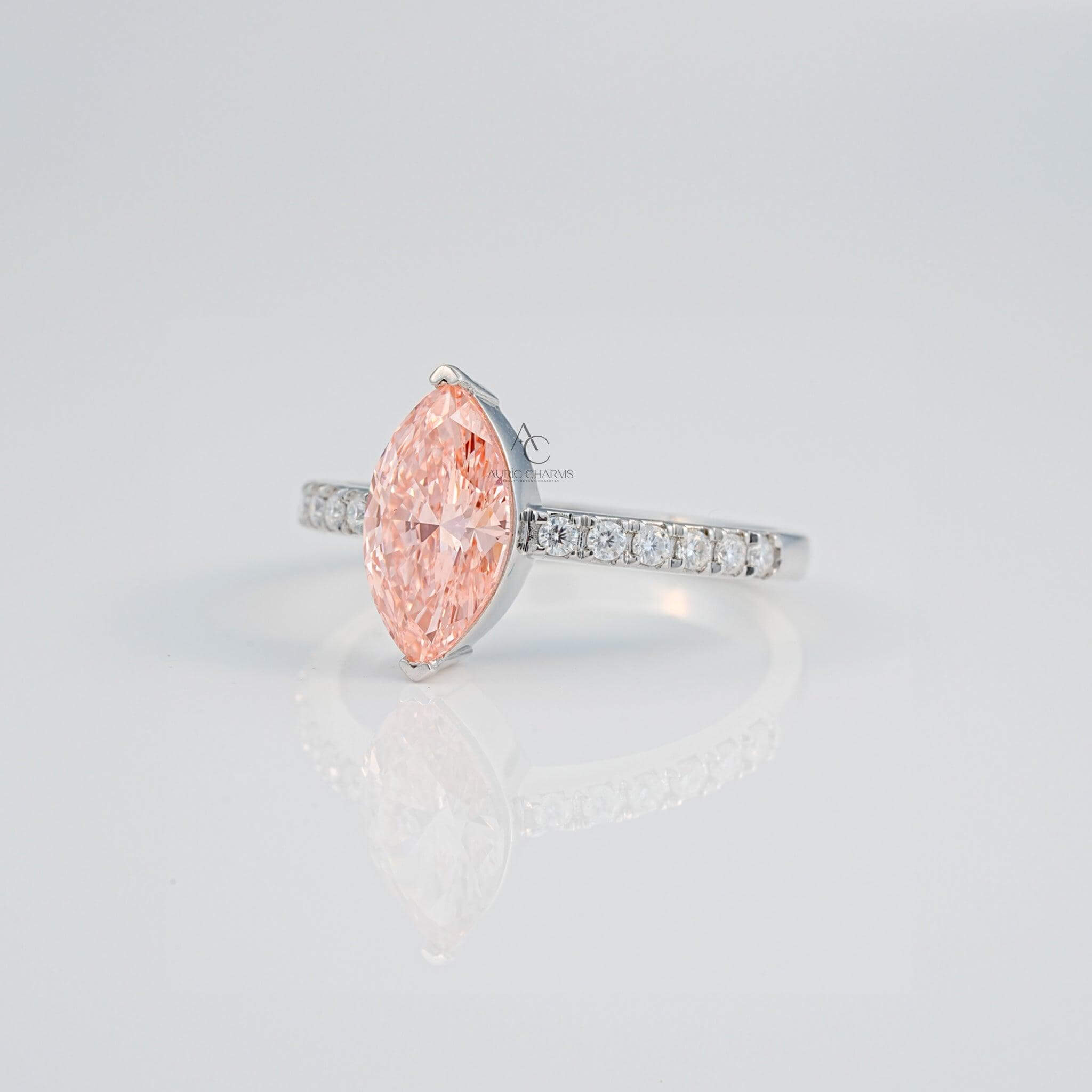 Side profile of marquise pink gem ring with sparkling diamonds on the silver band.