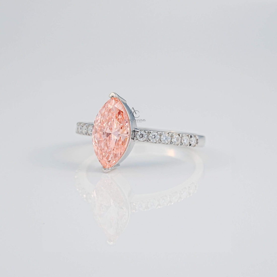 Side profile of marquise pink gem ring with sparkling diamonds on the silver band.
