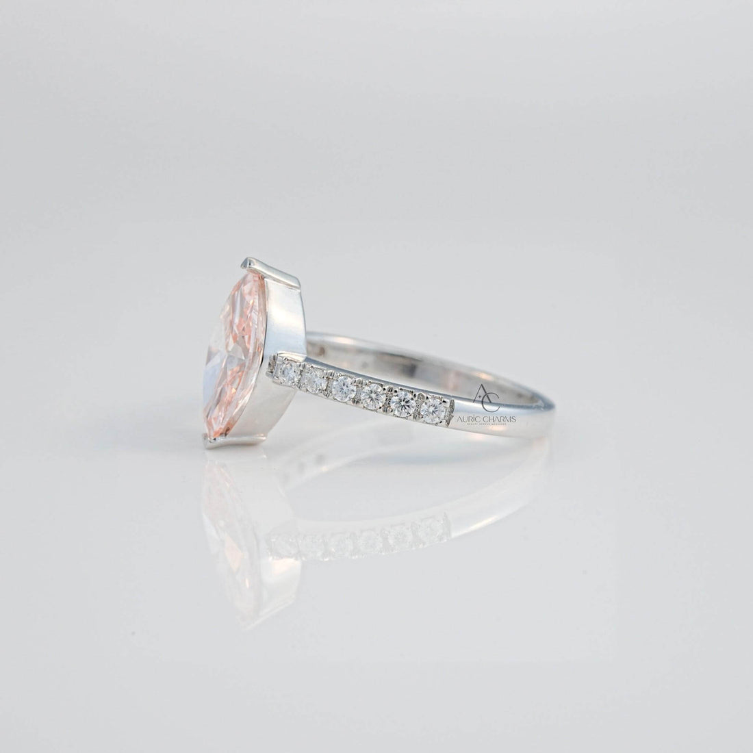 Elegant pink gemstone ring with diamonds showcased in a rear angle, set in silver.