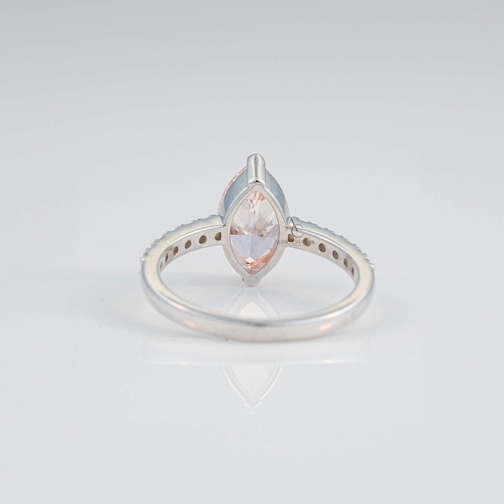 Top view of marquise pink gemstone with diamonds, highlighting the intricate silver design.