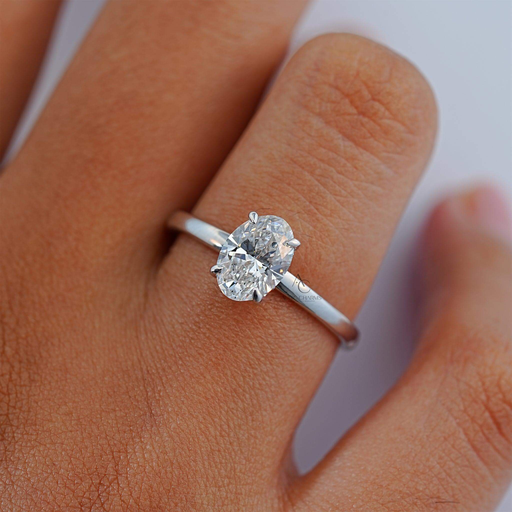 Oval-cut diamond solitaire ring worn on a hand, highlighting elegance and brilliance.