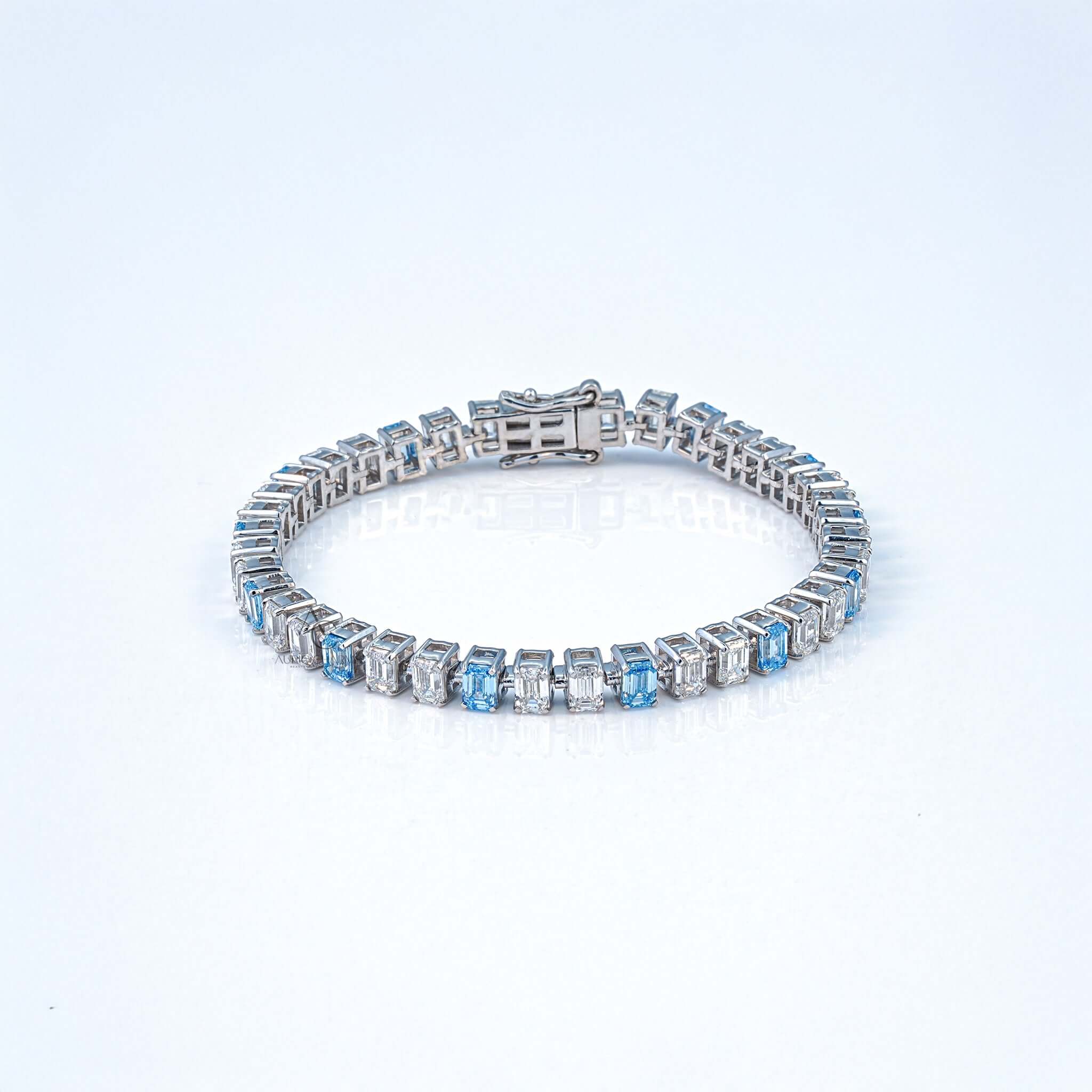 Front view of lab-grown diamond and sapphire tennis bracelet set in polished white gold.