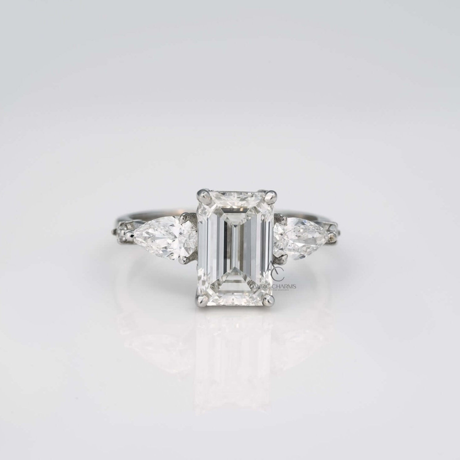 Emerald cut lab diamond ring with pear side stones, front view.
