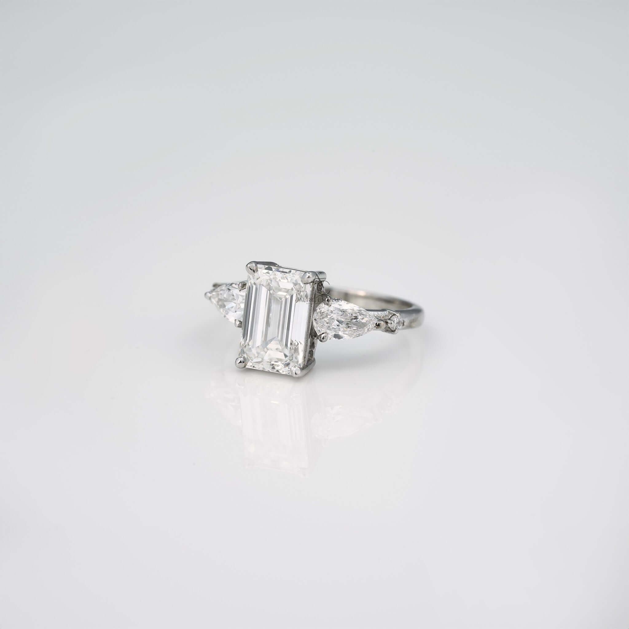 Emerald cut lab diamond ring, angled side view with pear accent stones.