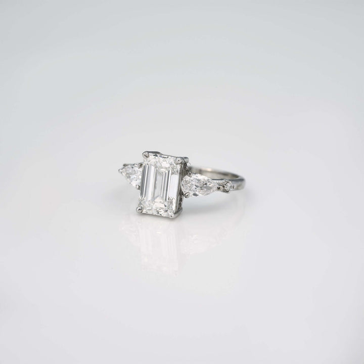 Emerald cut lab diamond ring, angled side view with pear accent stones.