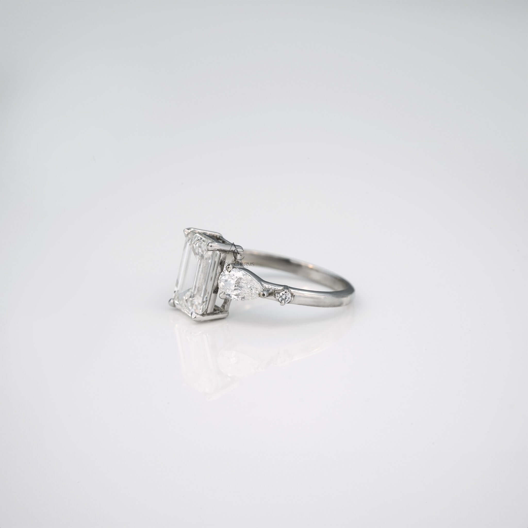 Side profile of emerald cut lab diamond ring with pear diamond accents.