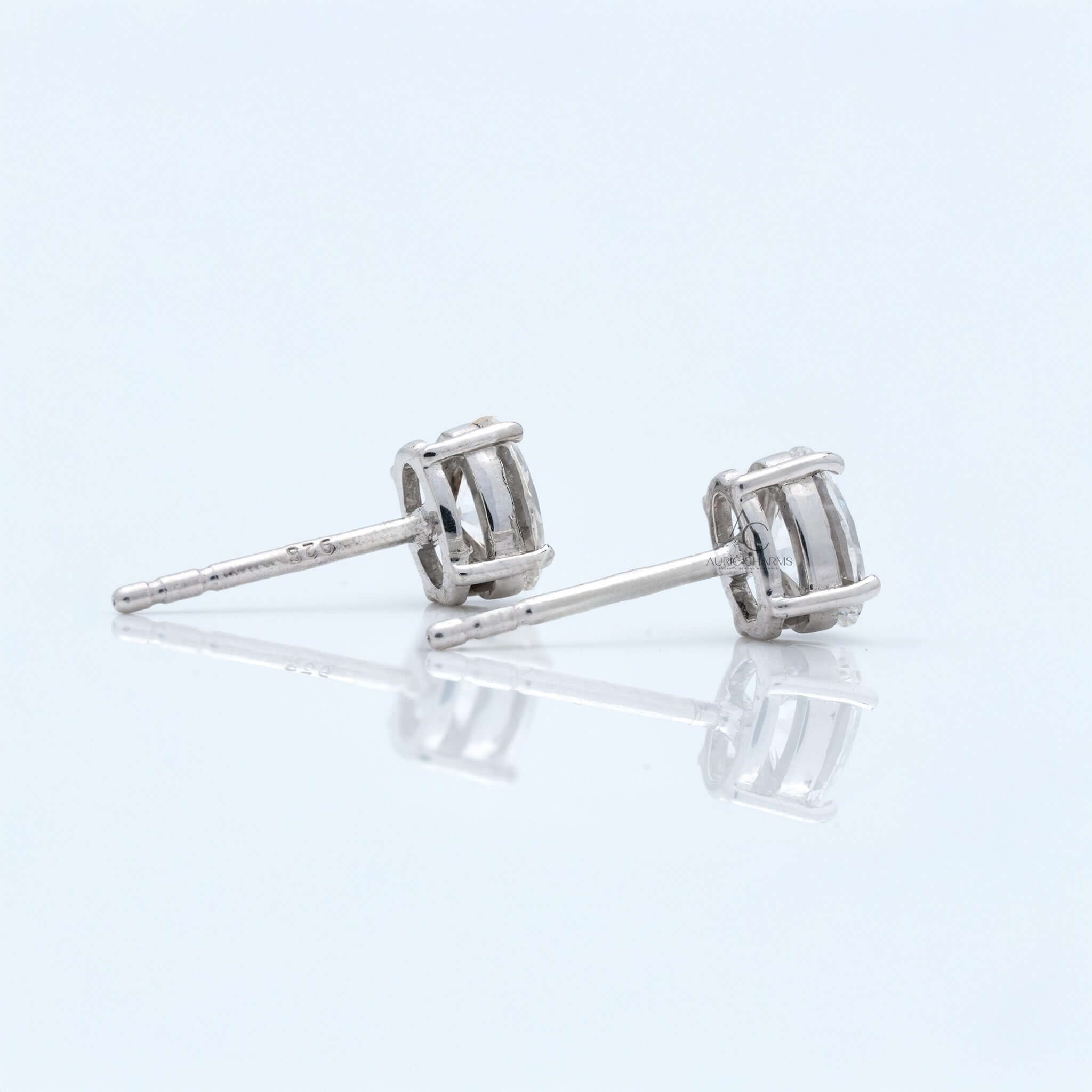 Side view of oval diamond stud earrings in white gold prong setting.