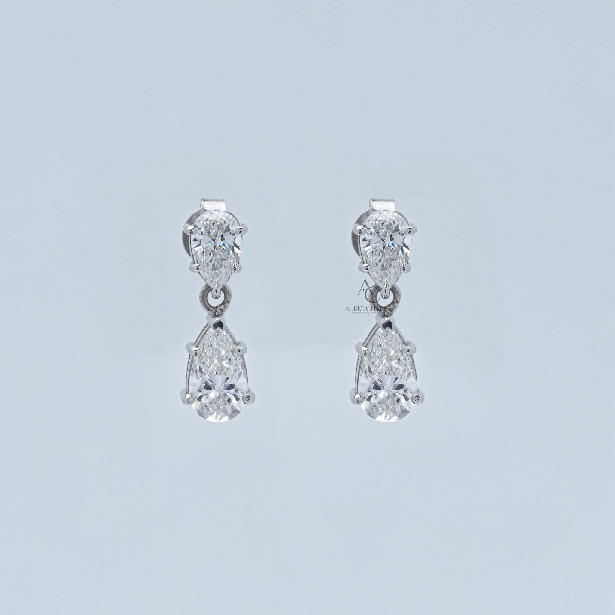 Diamond drop earrings with pear-shaped stones in a two-tier design set in silver.
