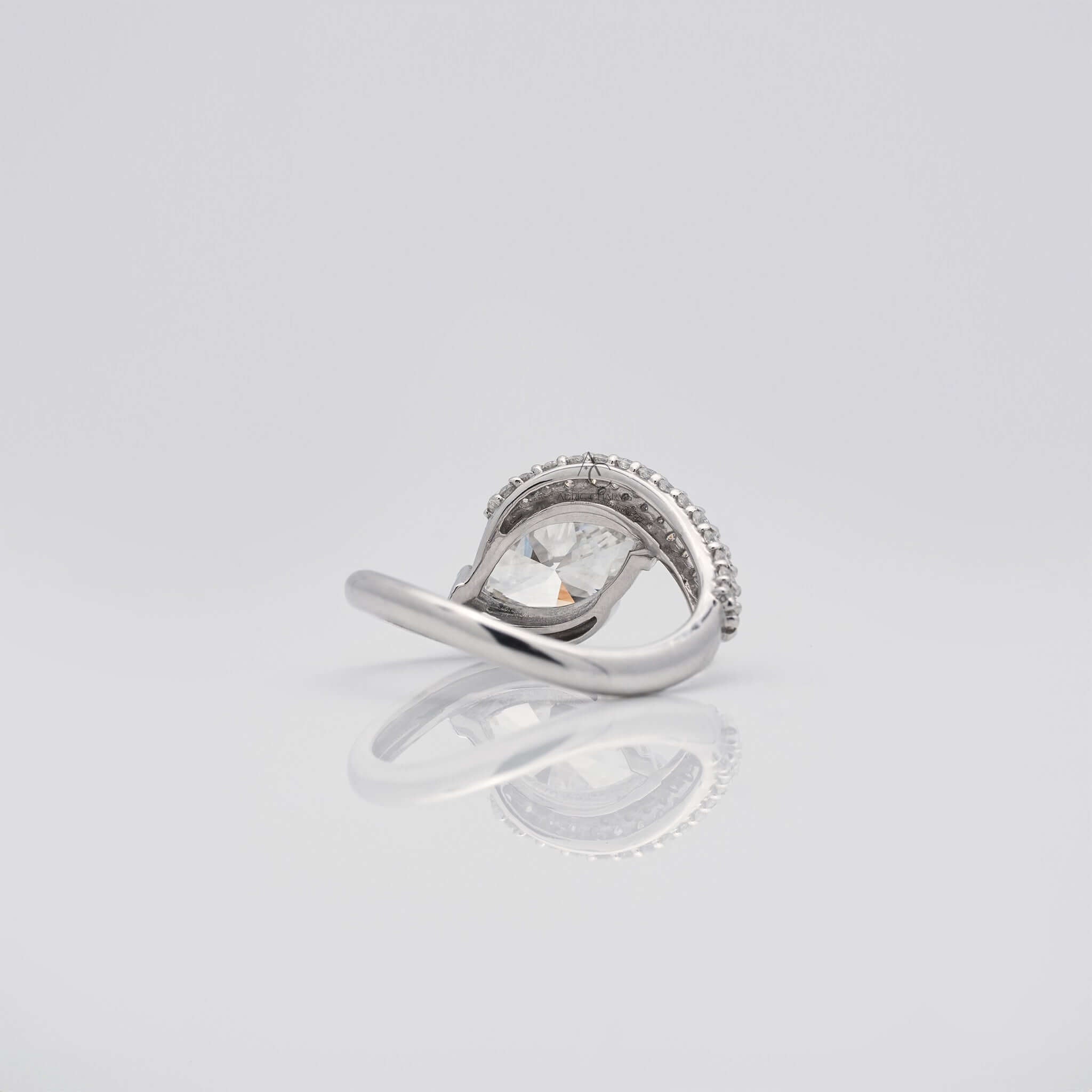 Bottom view of pear-shaped diamond ring showing prong setting and curved band design.