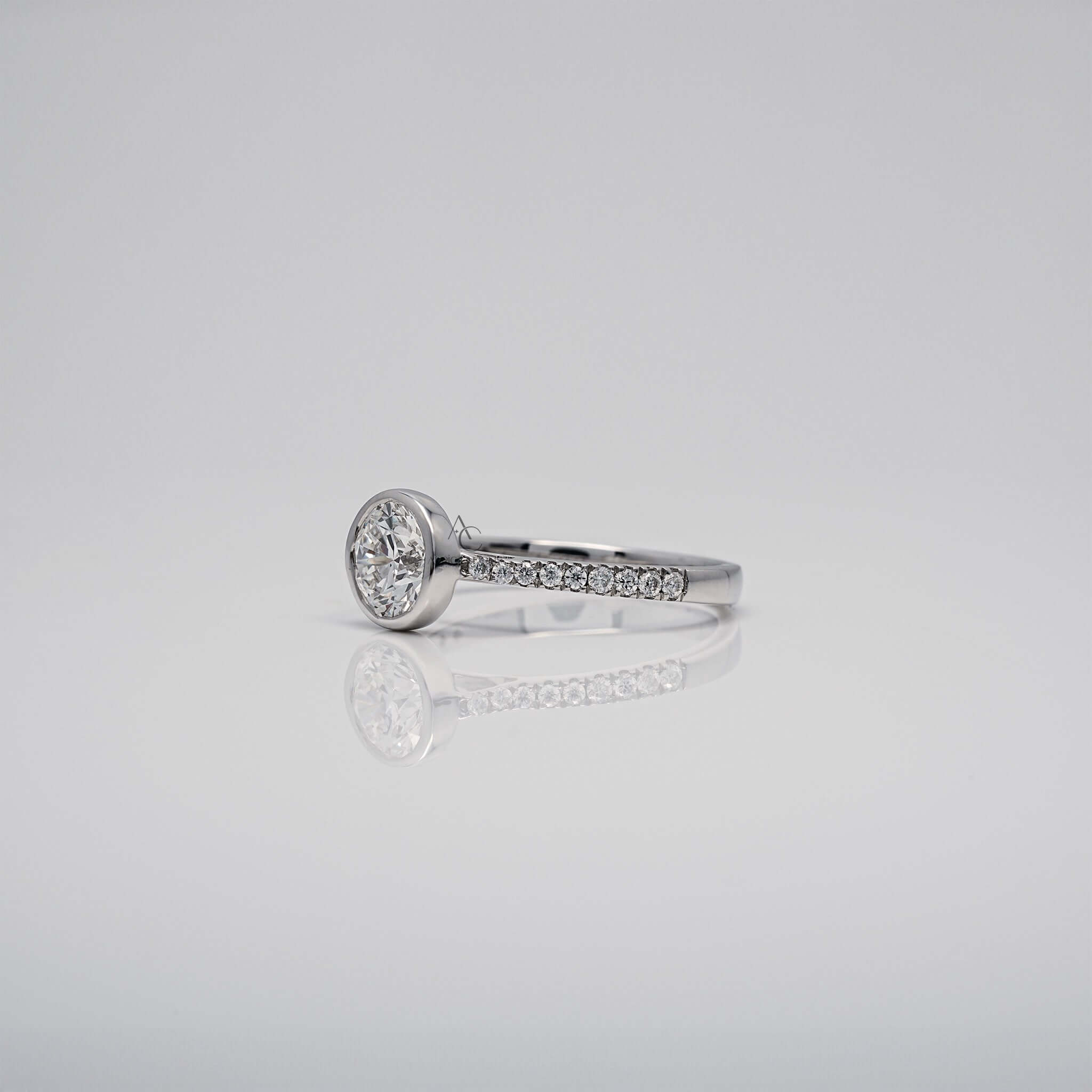 Angled view of bezel-set diamond ring with diamonds on band.