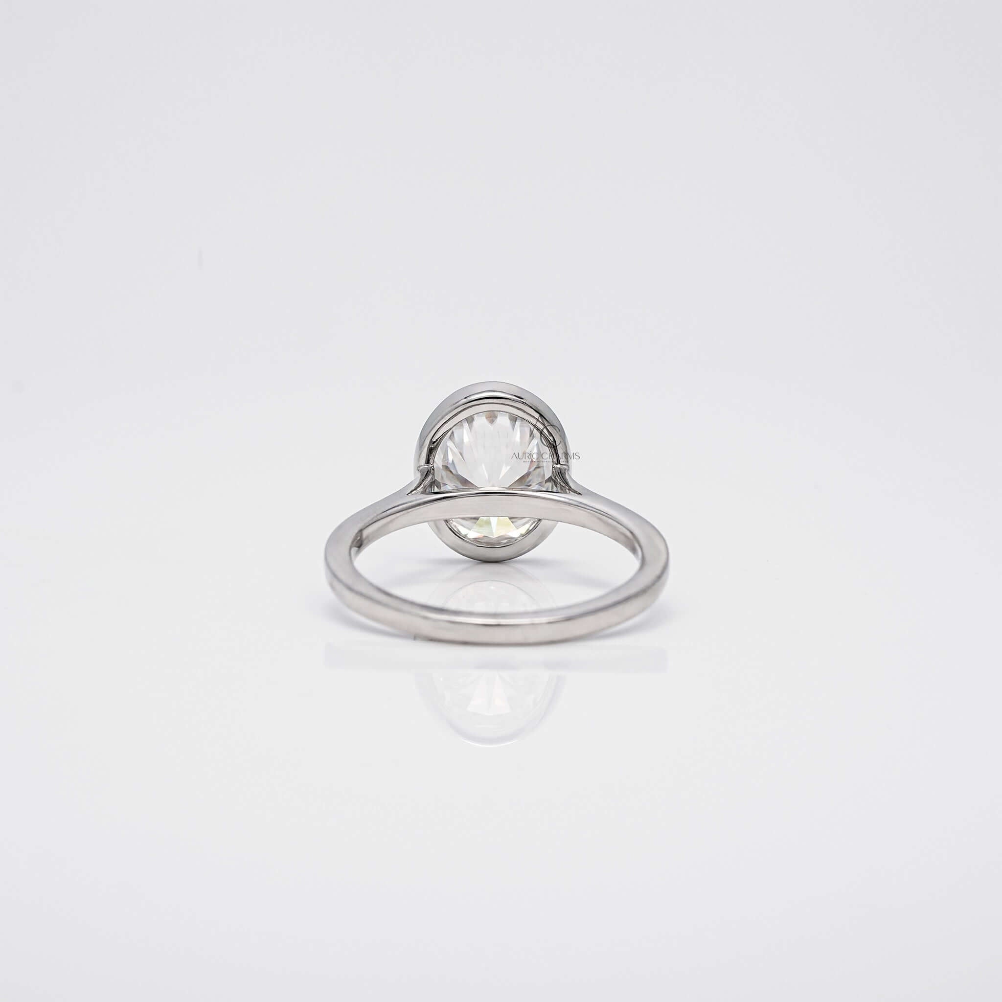 Back view of oval diamond ring showing bezel and smooth band.