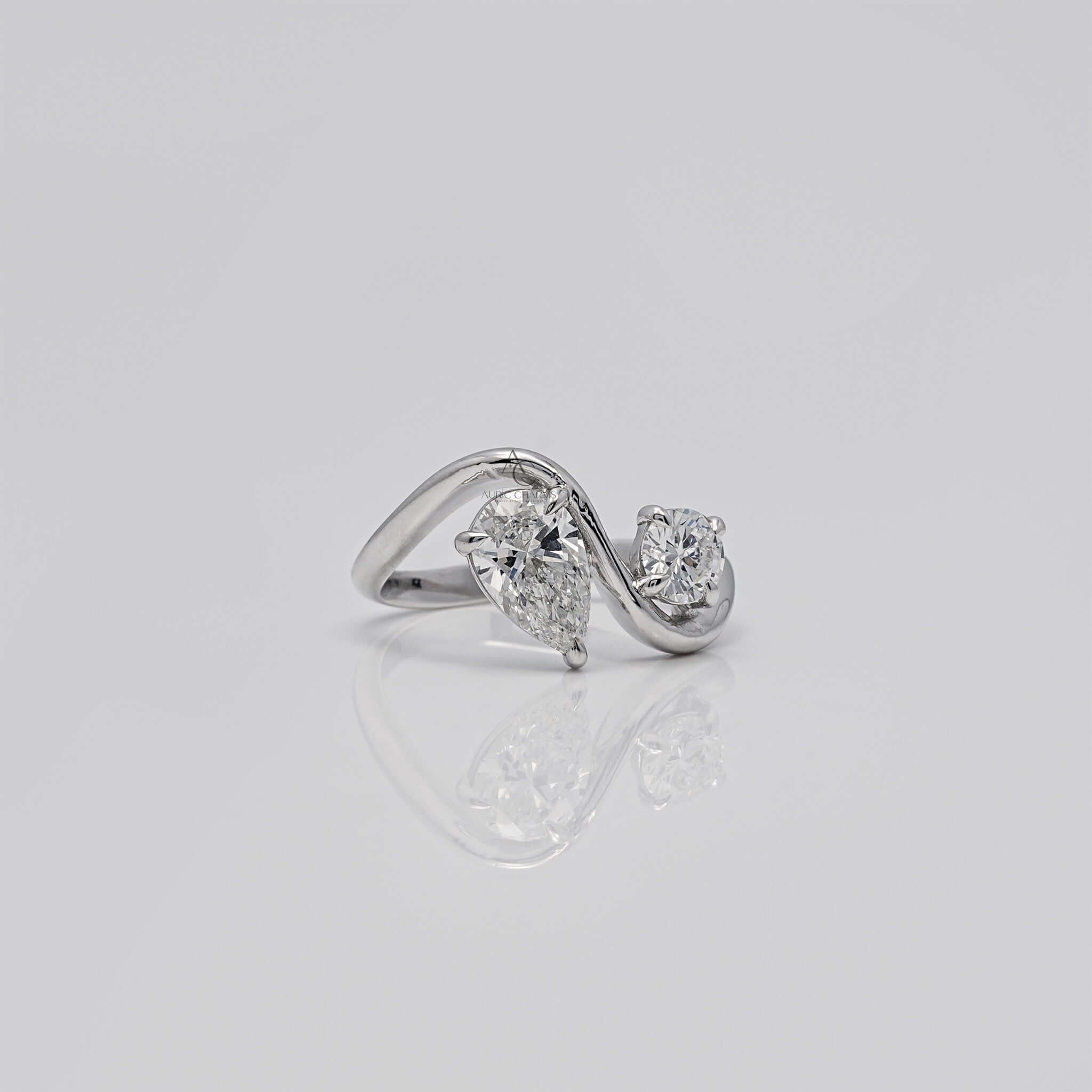 Side angle of pear and round diamond bypass ring.