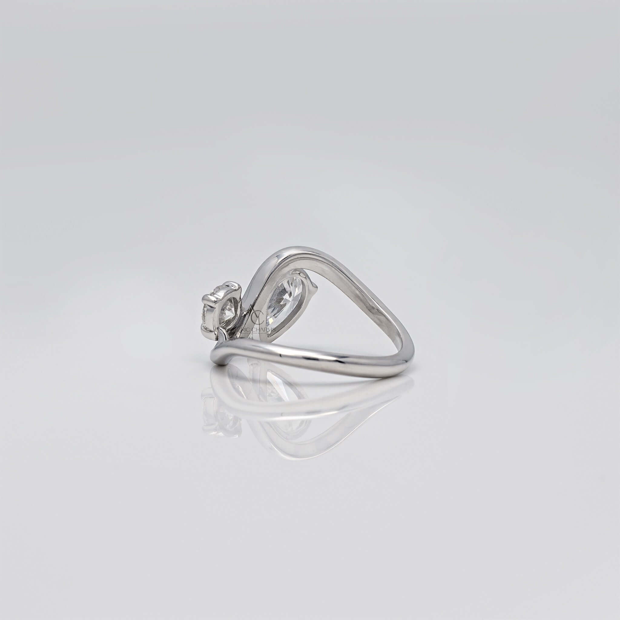 Rear view of pear and round diamond bypass ring.