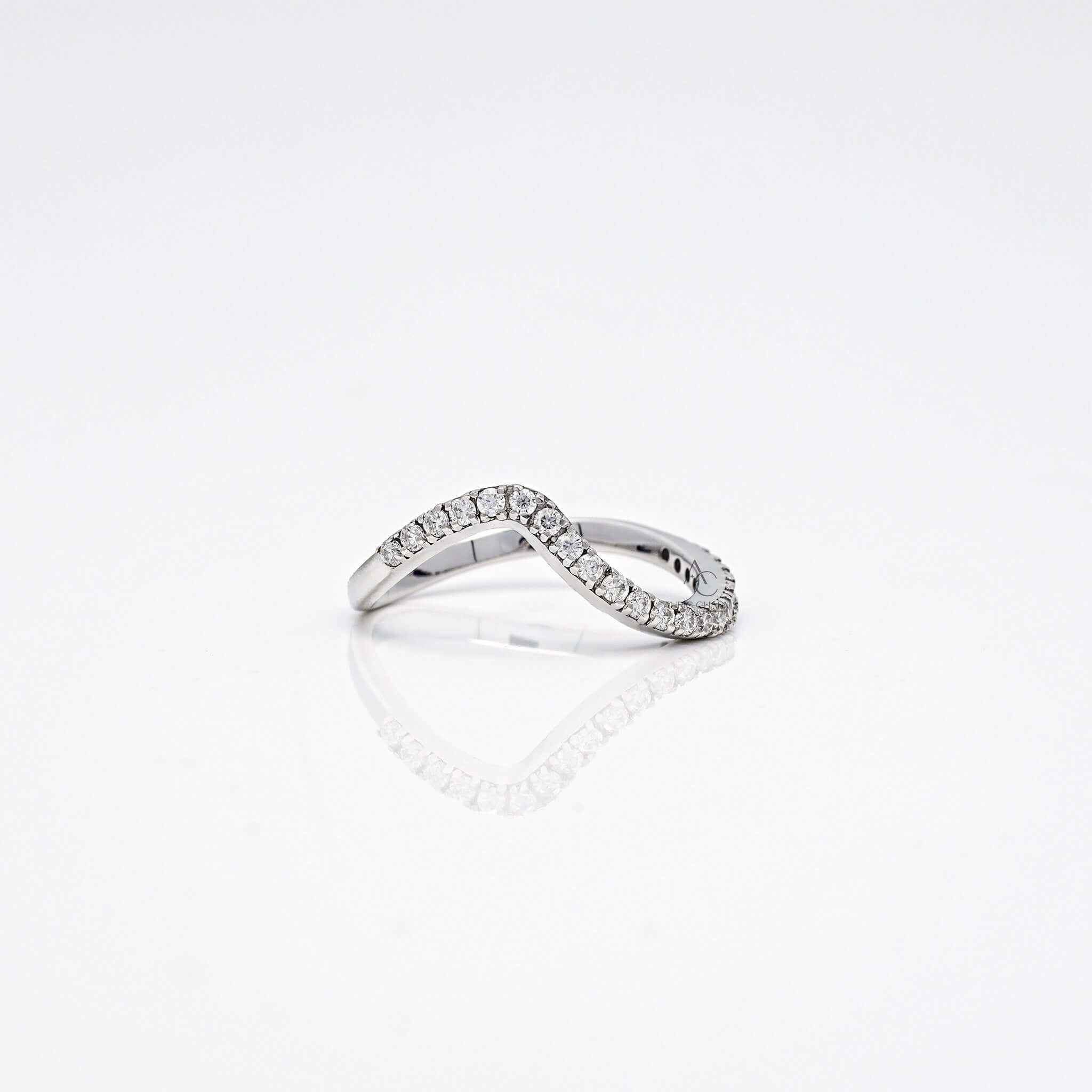 Wavy diamond band in white gold with a modern curved design.