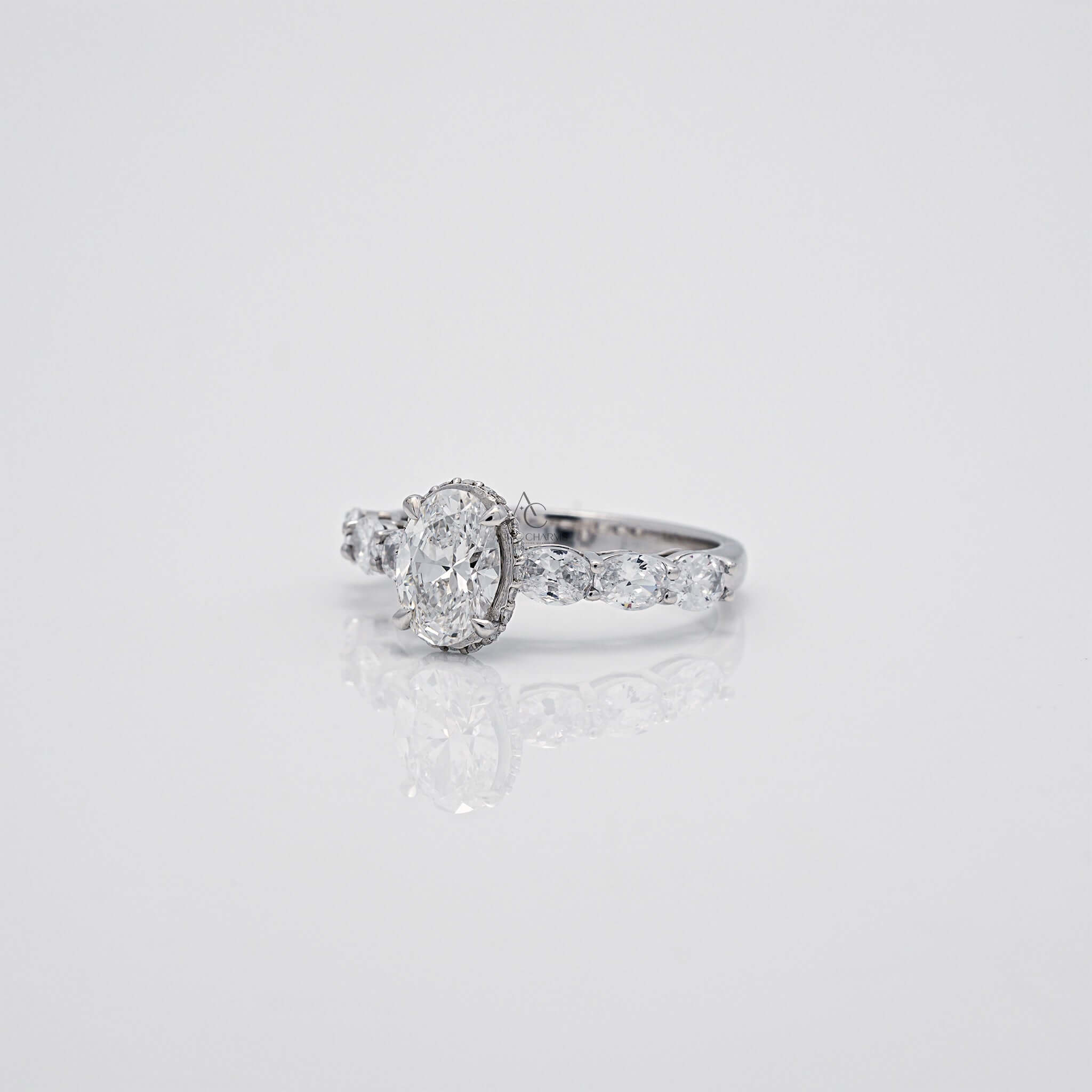 Side view of oval diamond ring with accented stones and polished band.
