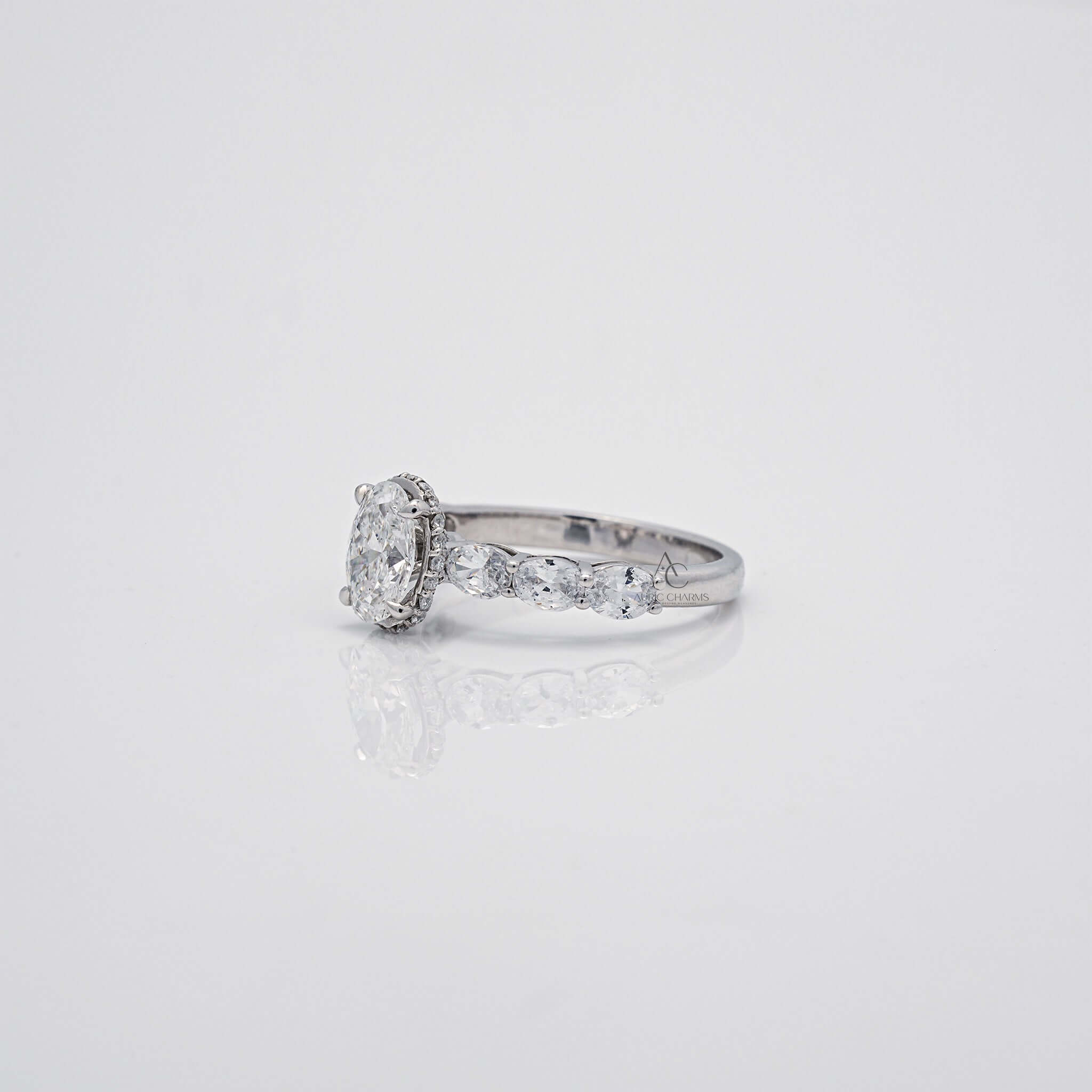 Angled oval diamond ring showing prong setting and side stones.
