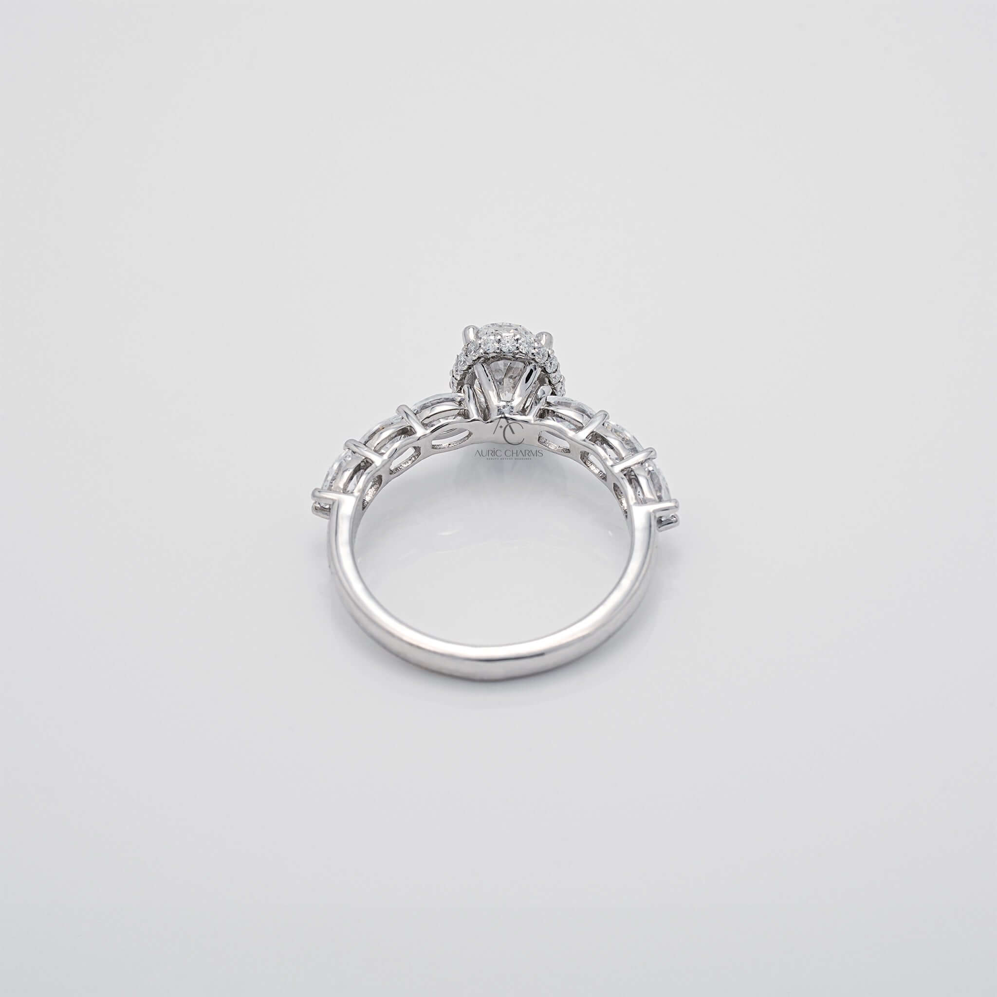 Top view of oval diamond ring with accent stones and polished band.