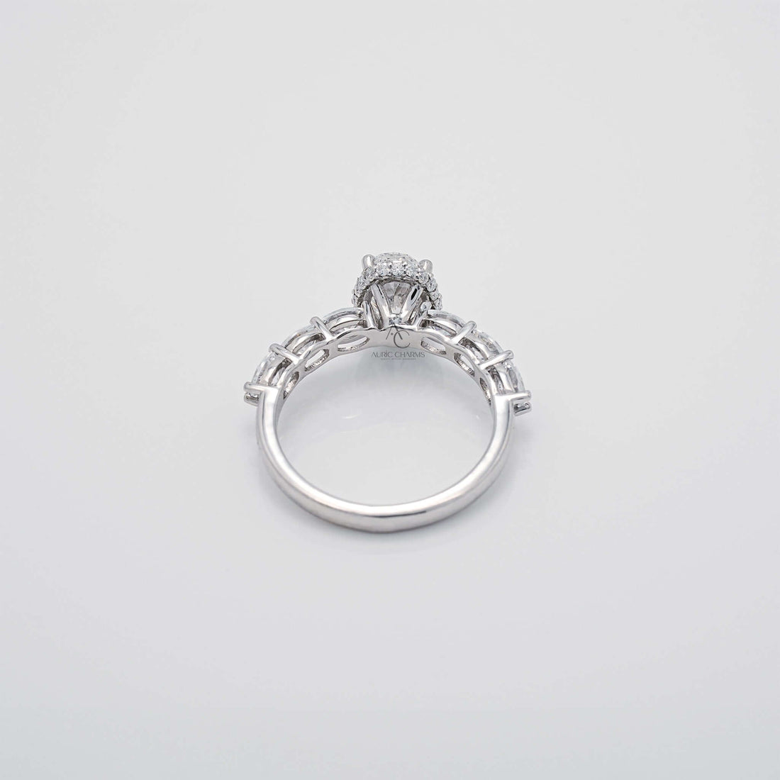Top view of oval diamond ring with accent stones and polished band.