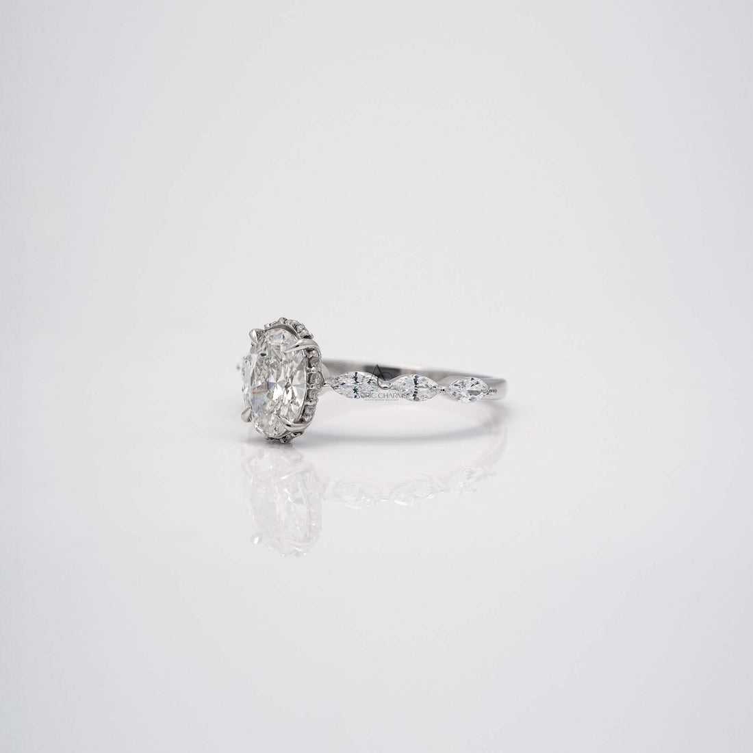 Side view of oval diamond ring with marquise accents in white gold.