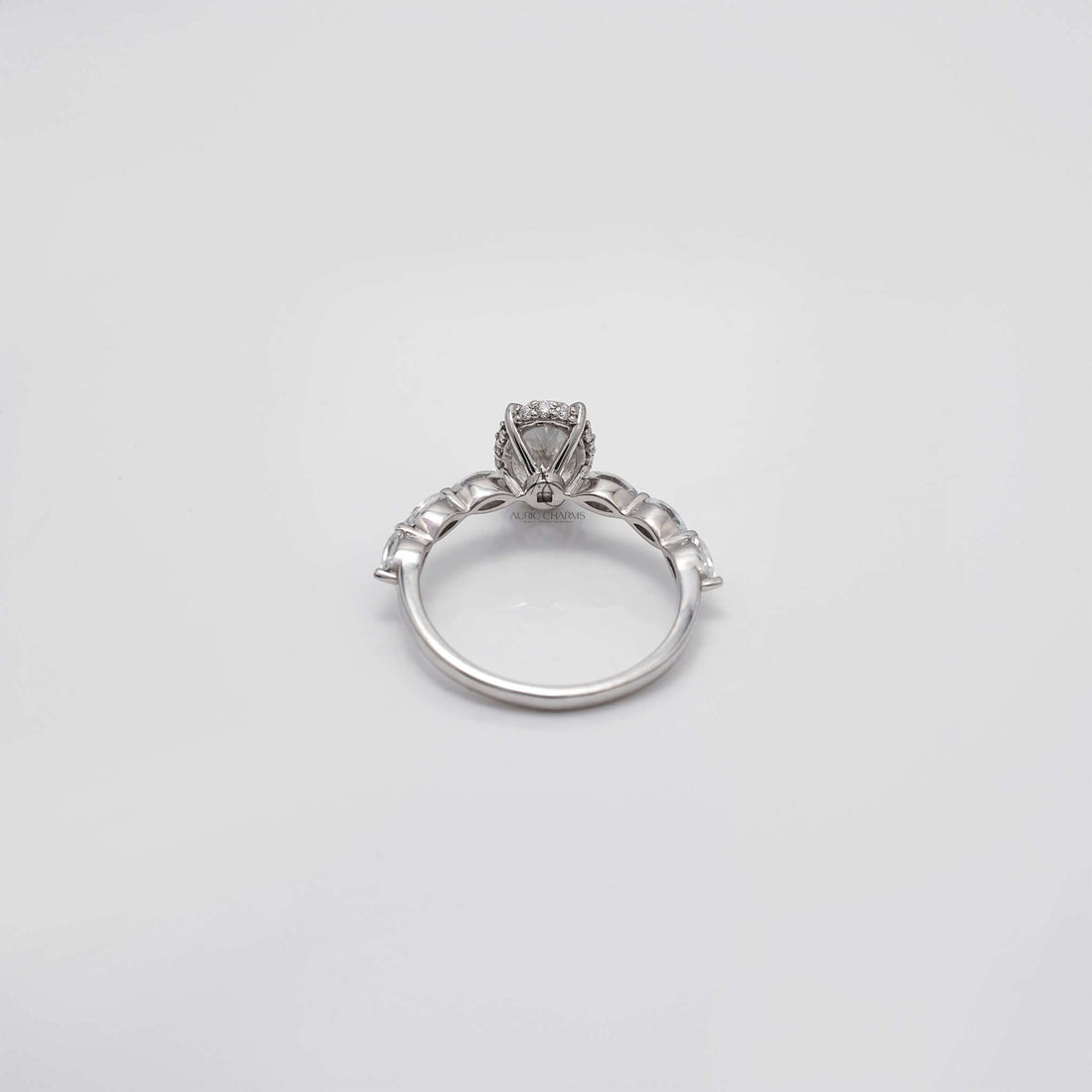Top view of oval diamond ring with prong and marquise side stones.
