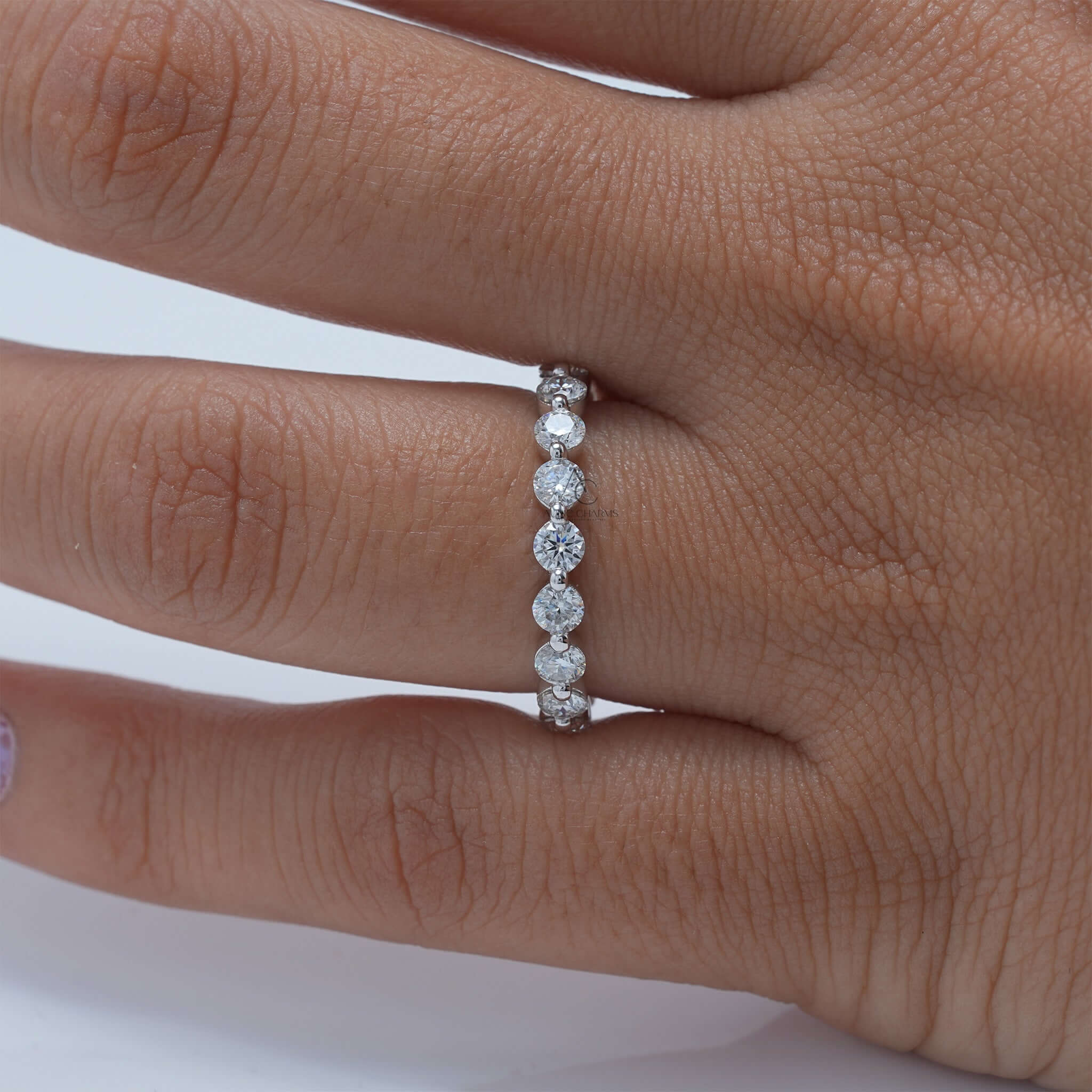 Diamond eternity band on finger showcasing brilliance.