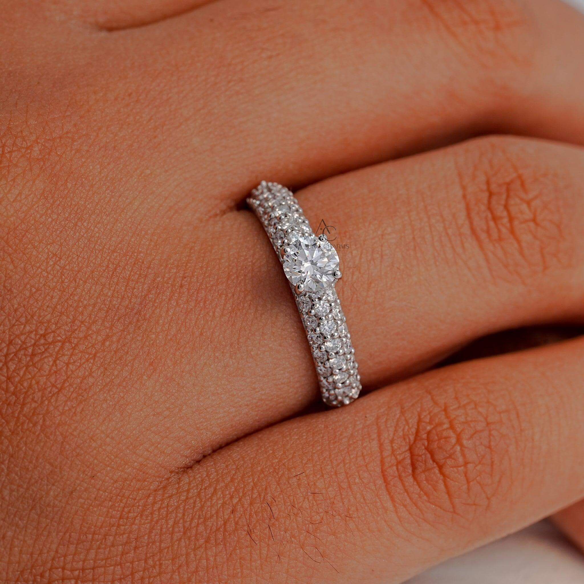 A hand model wearing a round-cut diamond pavé ring, highlighting the brilliance and sparkle of the ethically sourced diamonds.