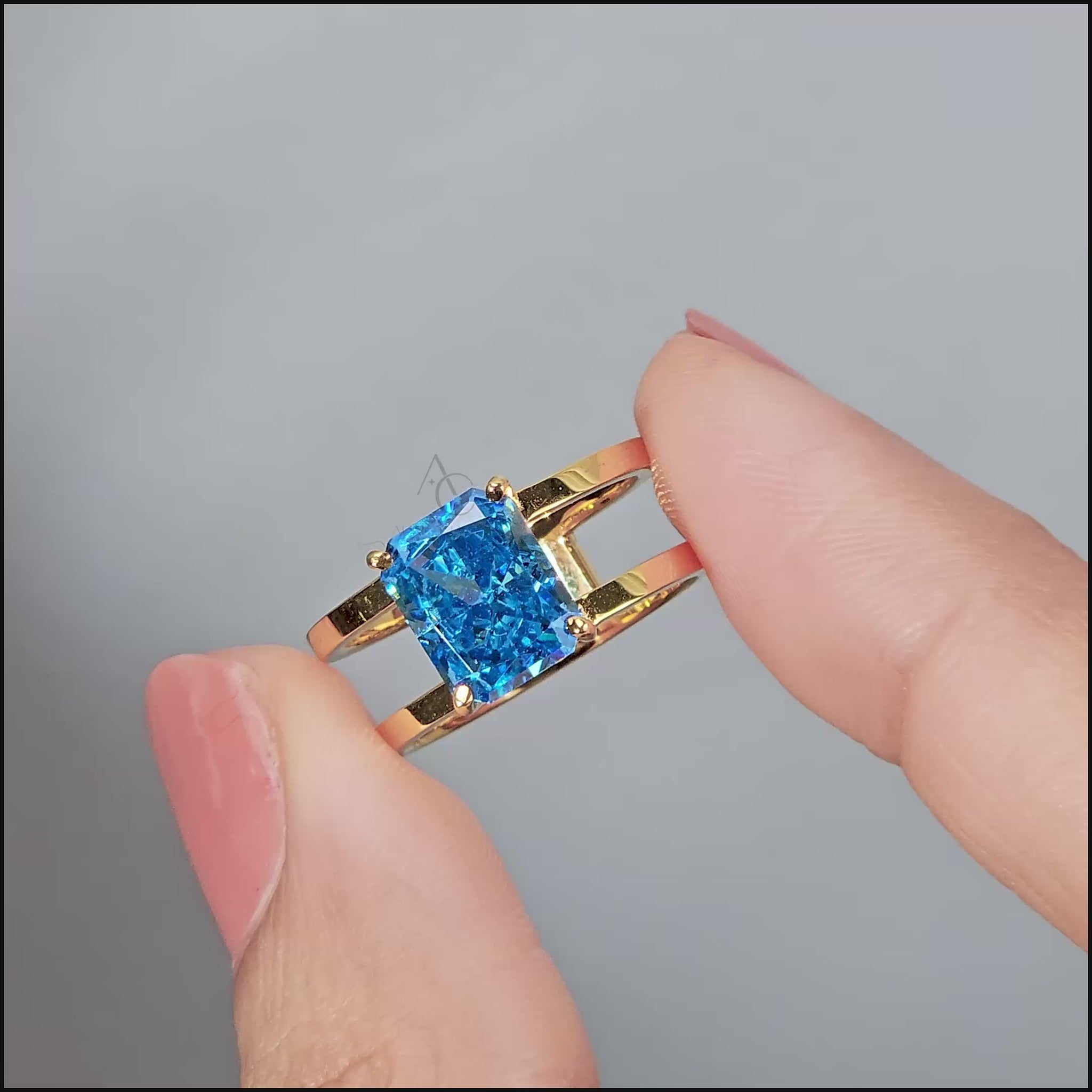 A gold ring with a rectangular-cut bright blue gemstone placed