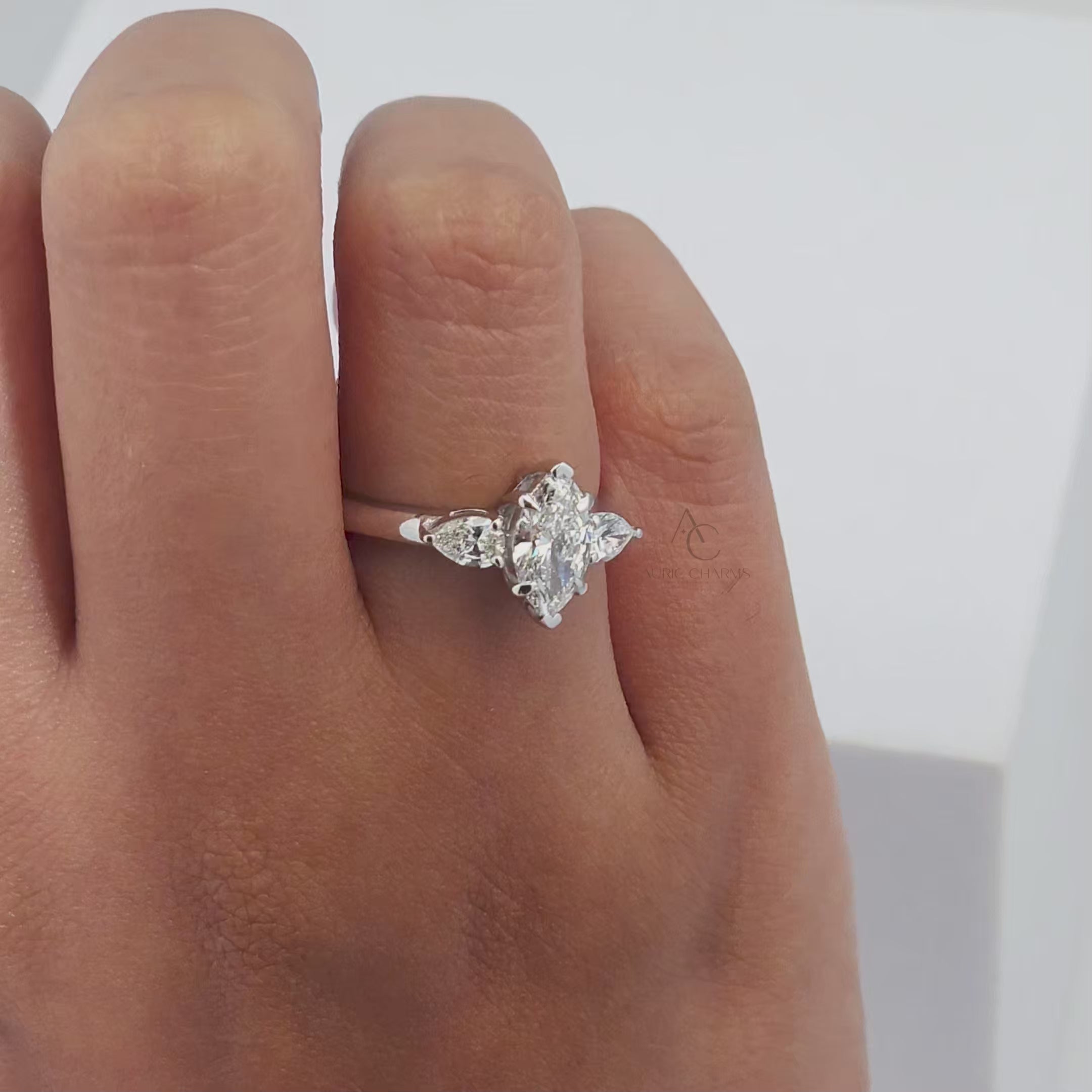 360-degree view of marquise diamond ring with pear accents, highlighting brilliance and design.