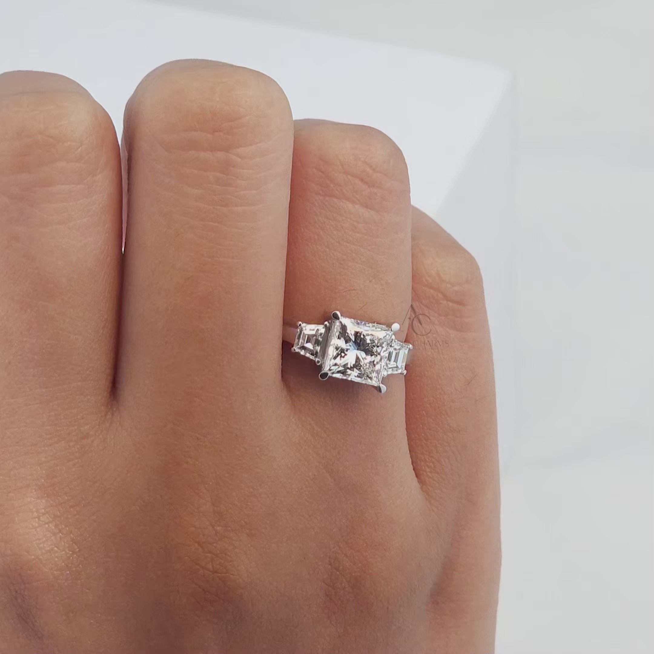 360-degree view of a princess-cut diamond engagement ring with baguette side stones in platinum.