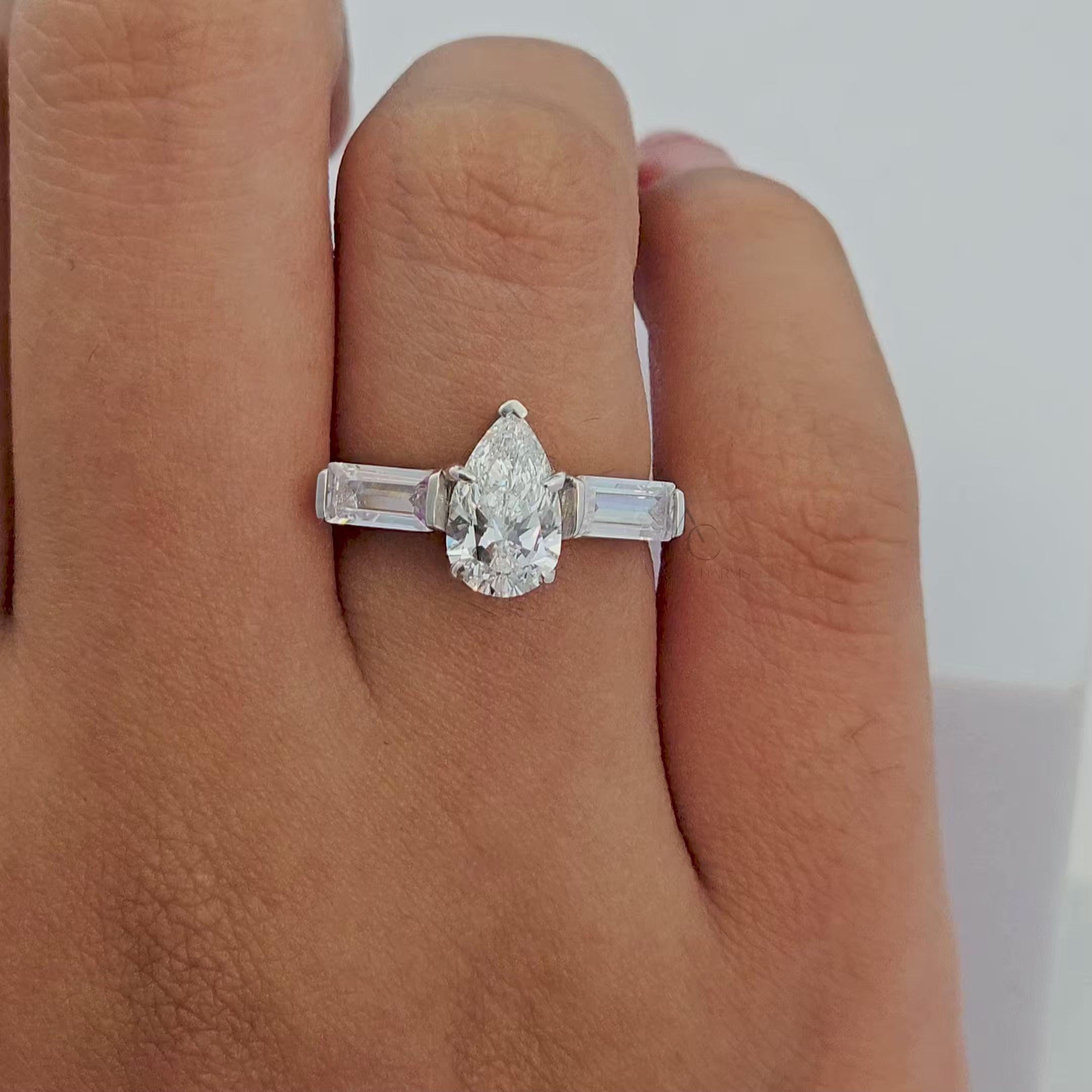 360-degree rotating video of a pear-cut diamond ring with tapered baguette side stones.