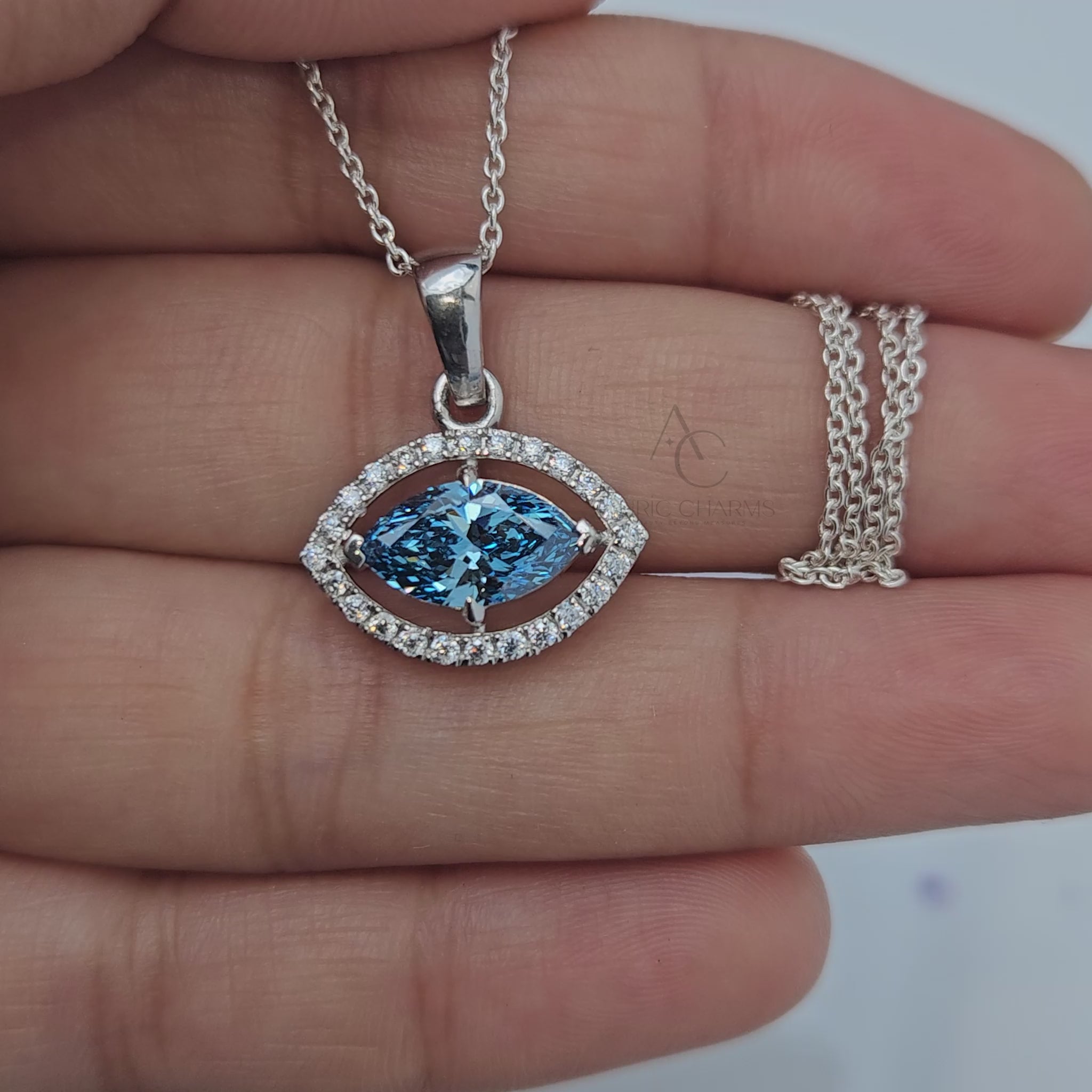 360-degree view of marquise blue sapphire and diamond halo pendant in white gold.