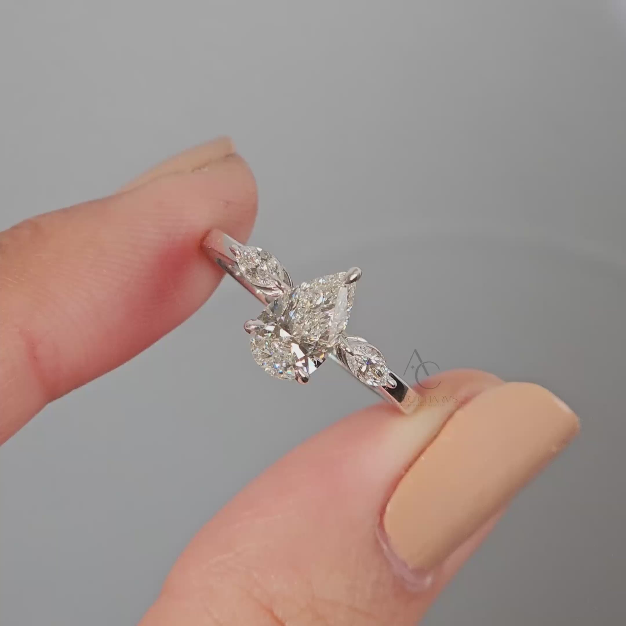 360-degree view of a pear-cut diamond ring with marquise side stones.